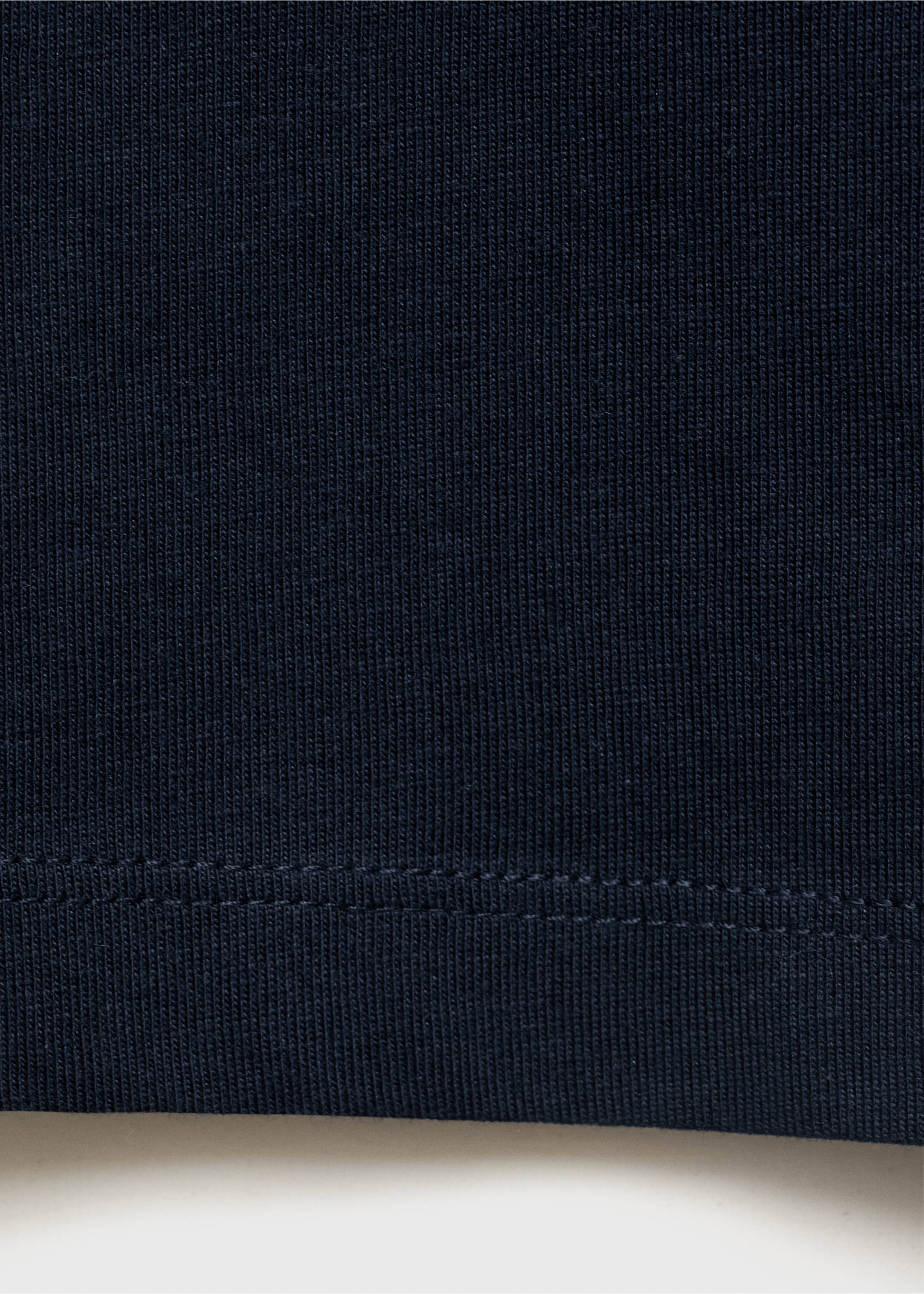 Close-up of dark navy blue ribbed fabric texture with a stitched hem., Navy. Ref: 17042909-00.