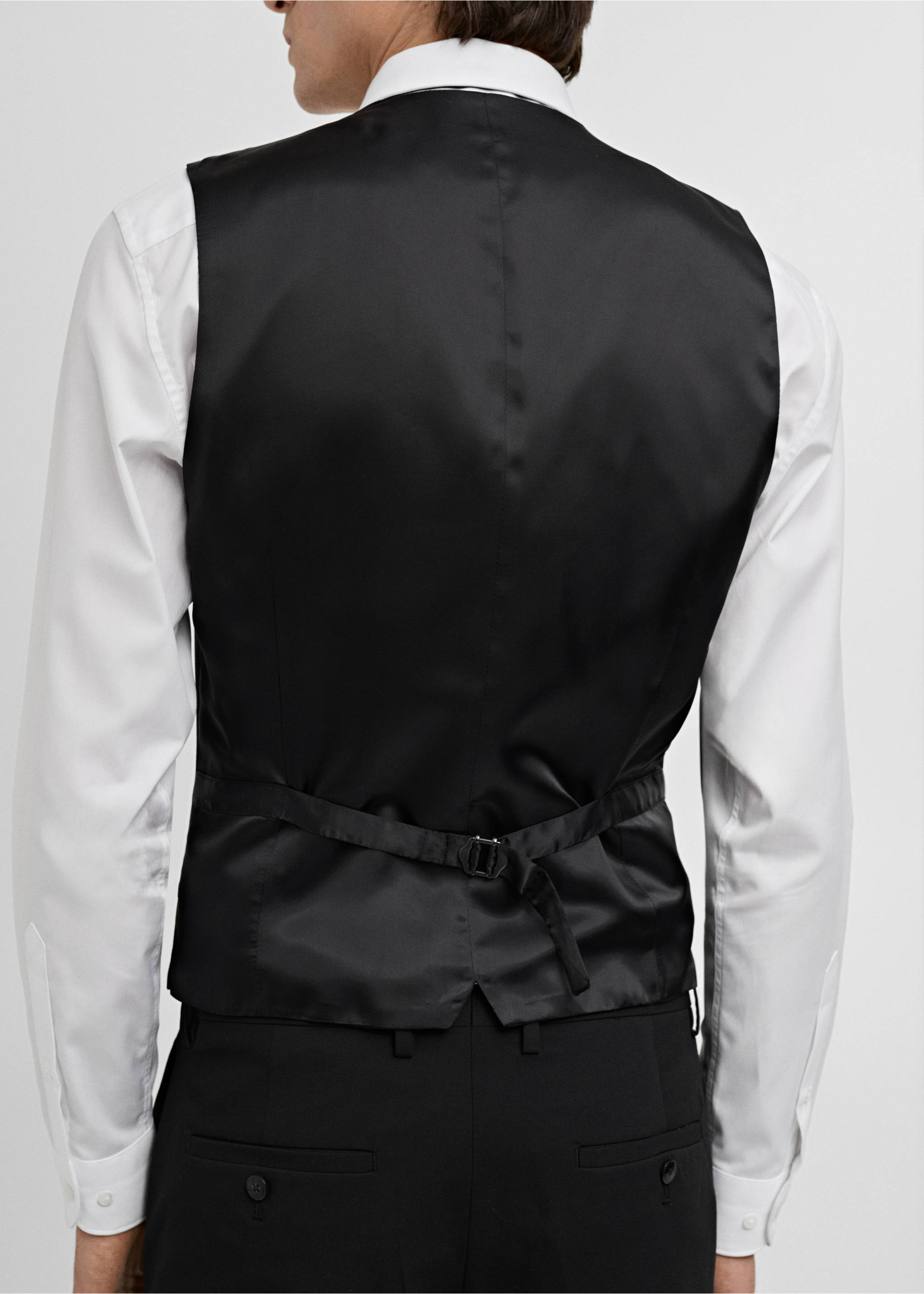 Black suit vest shown from the back, featuring an adjustable back strap., Black. Ref: 17051236-00.