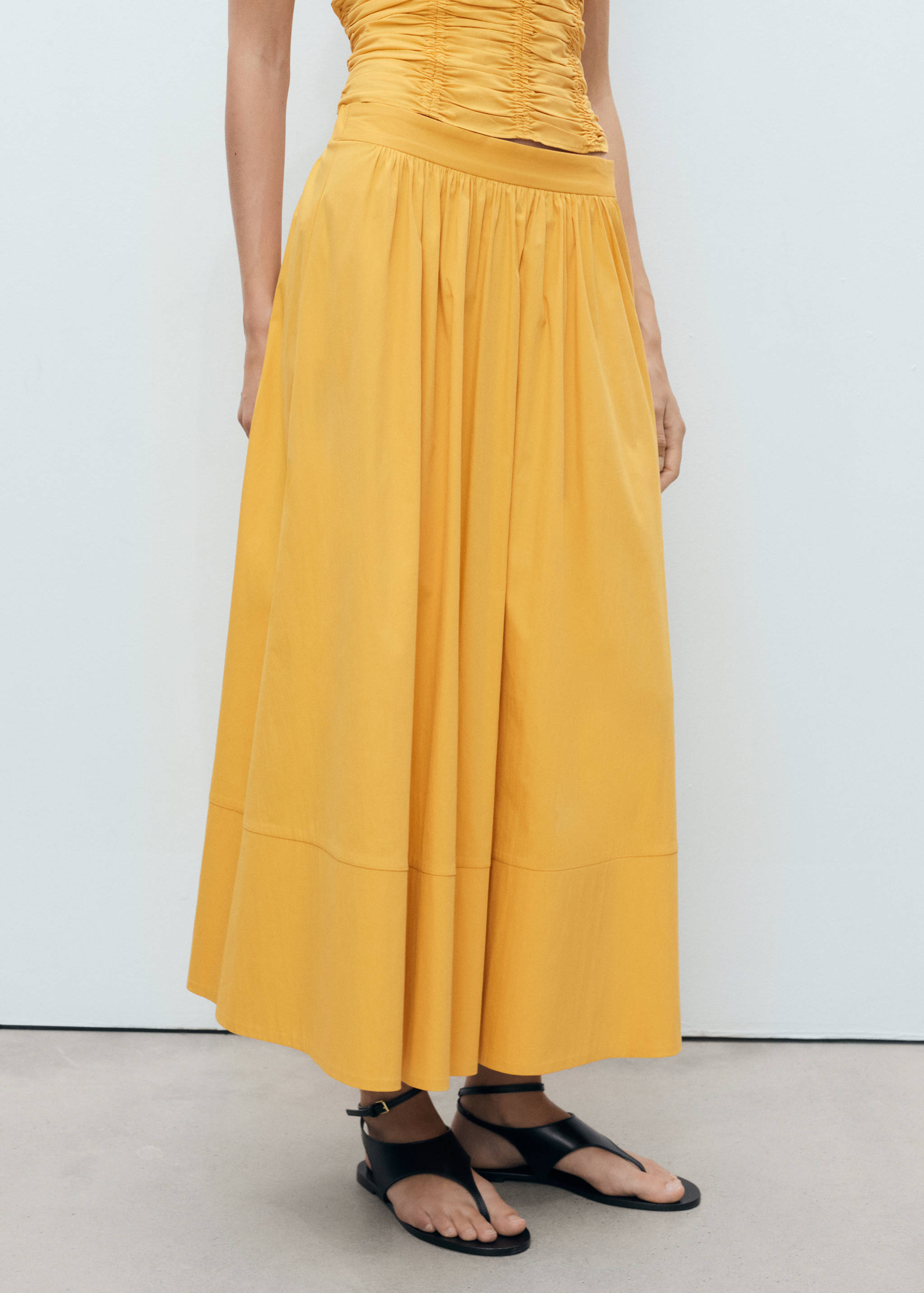 Lång rynkad kjol - Bild av mittparti