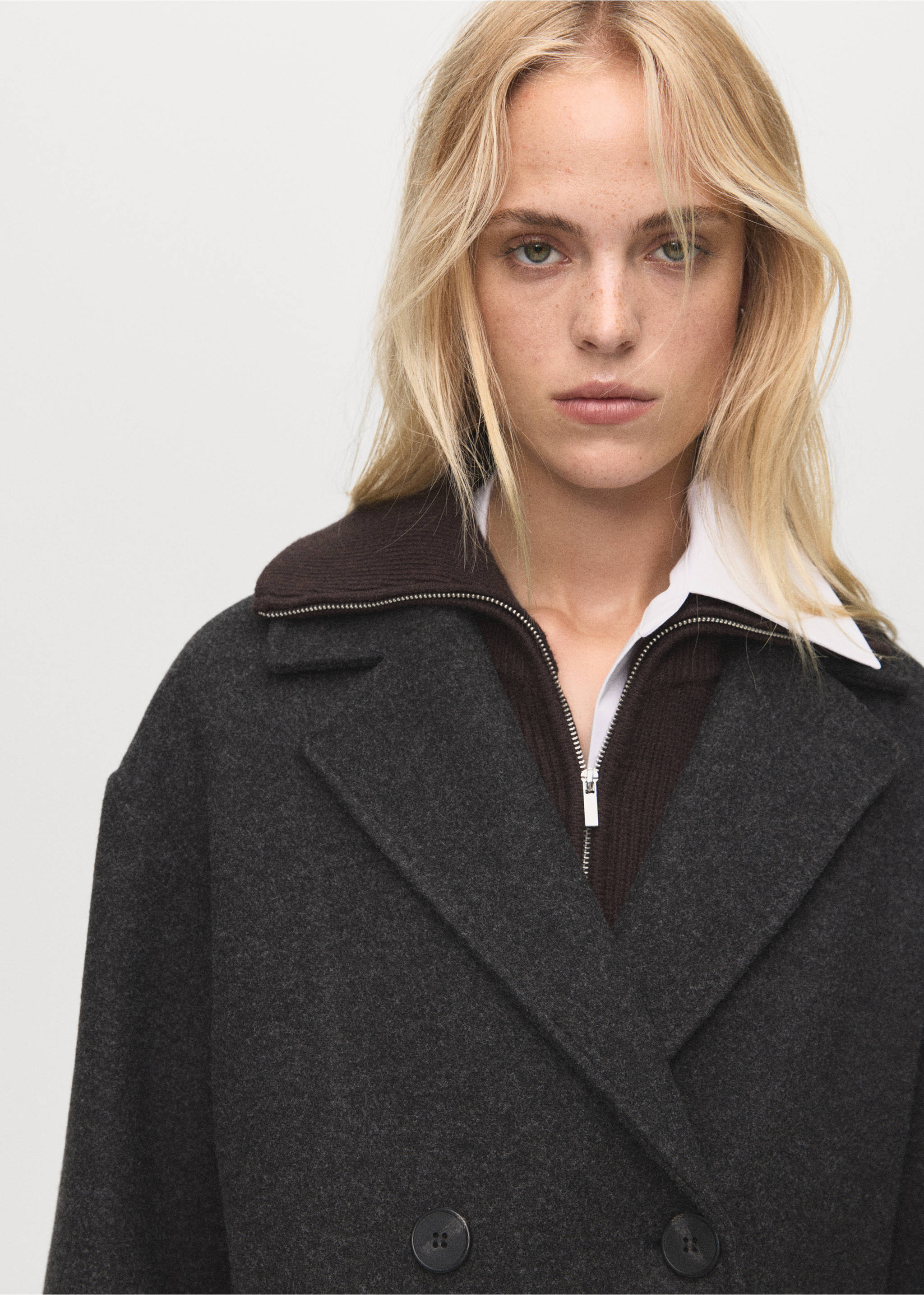 Close-up of a dark grey coat with wide lapels and double-breasted buttons., Charcoal. Ref: 17095812-00.