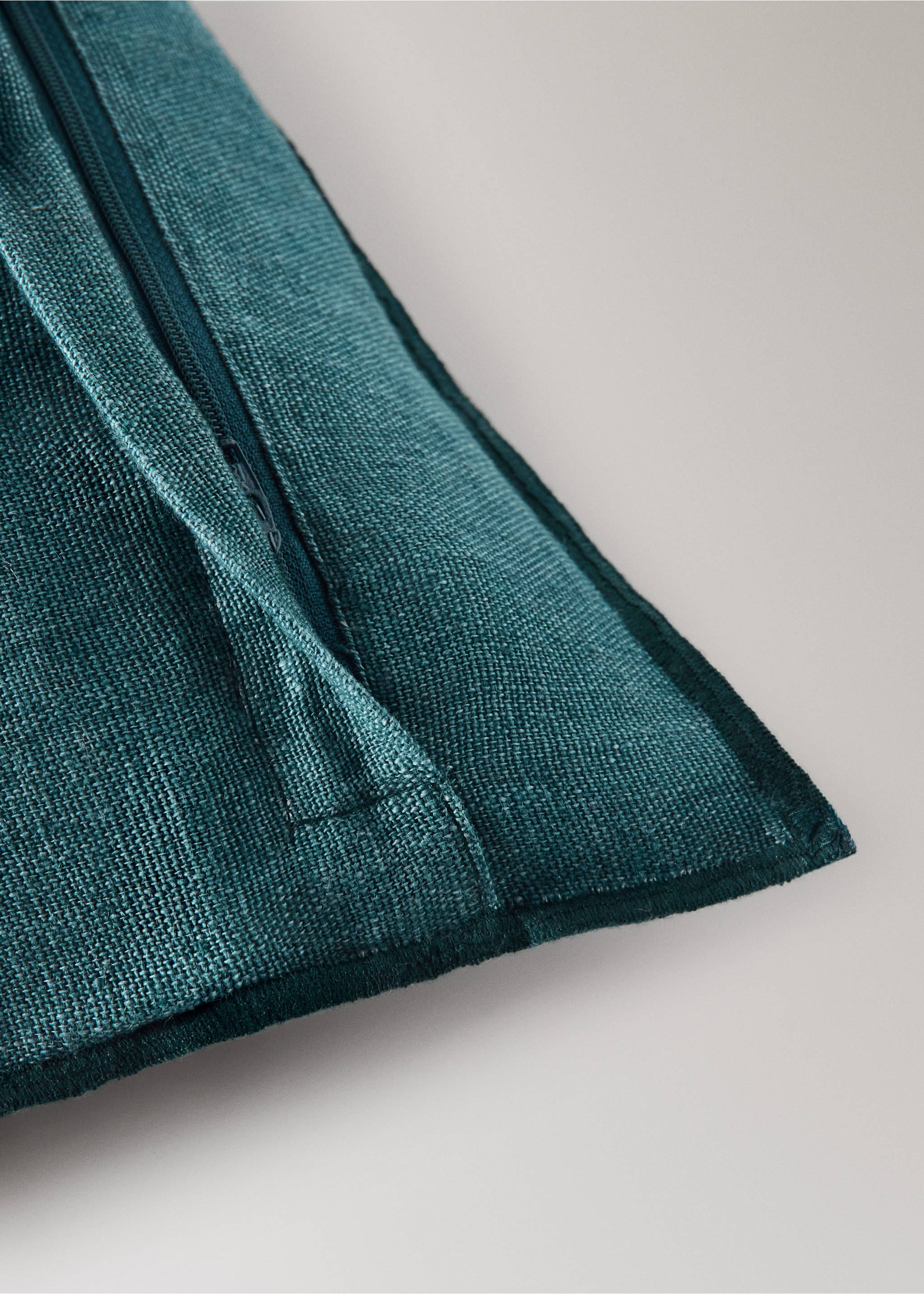 Close-up of a dark teal cushion cover showing its woven texture and zip detail., Petrol Blue. Ref: 37001481-00.
