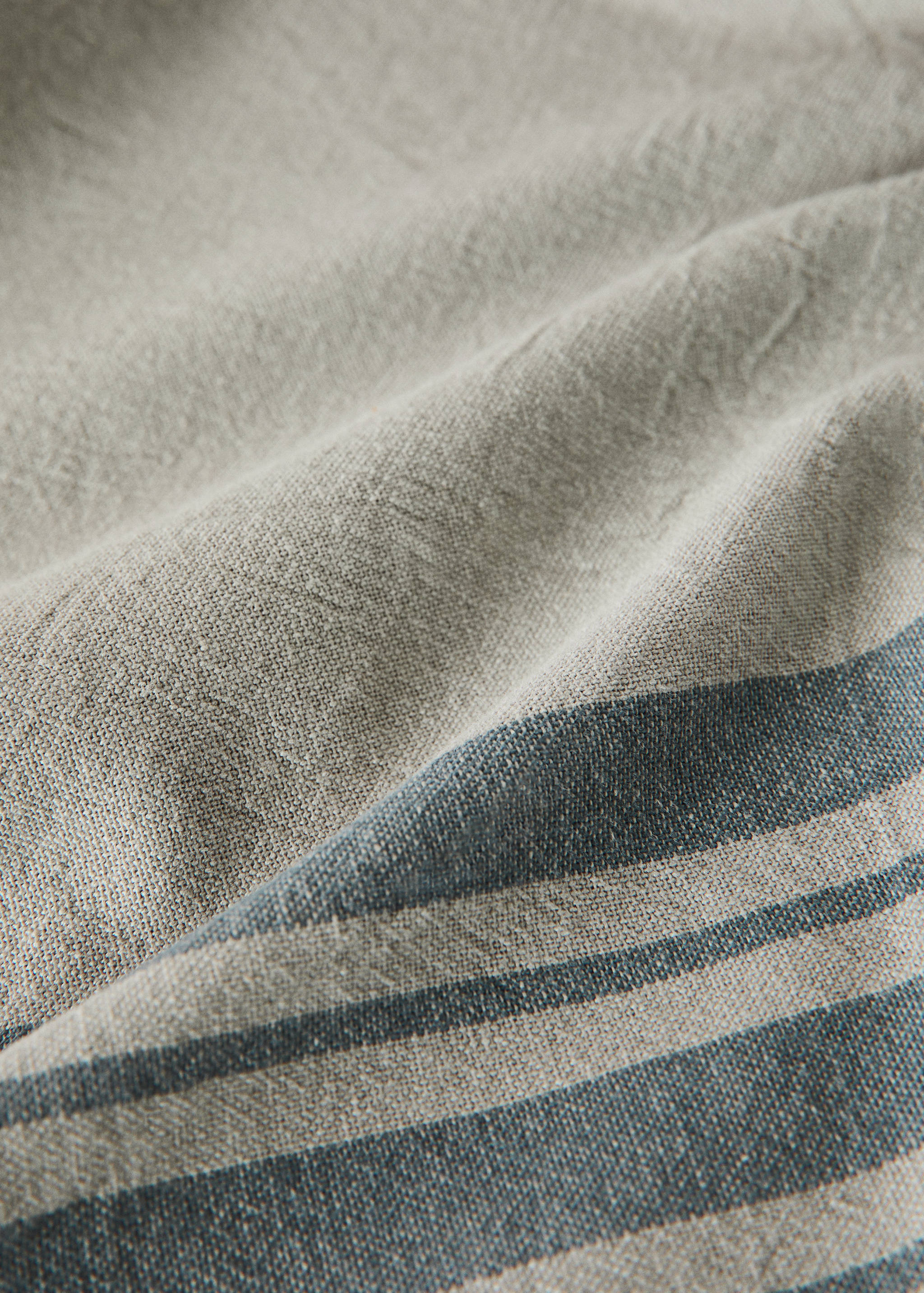 Close-up of a striped neutral tablecloth with visible textured weave.