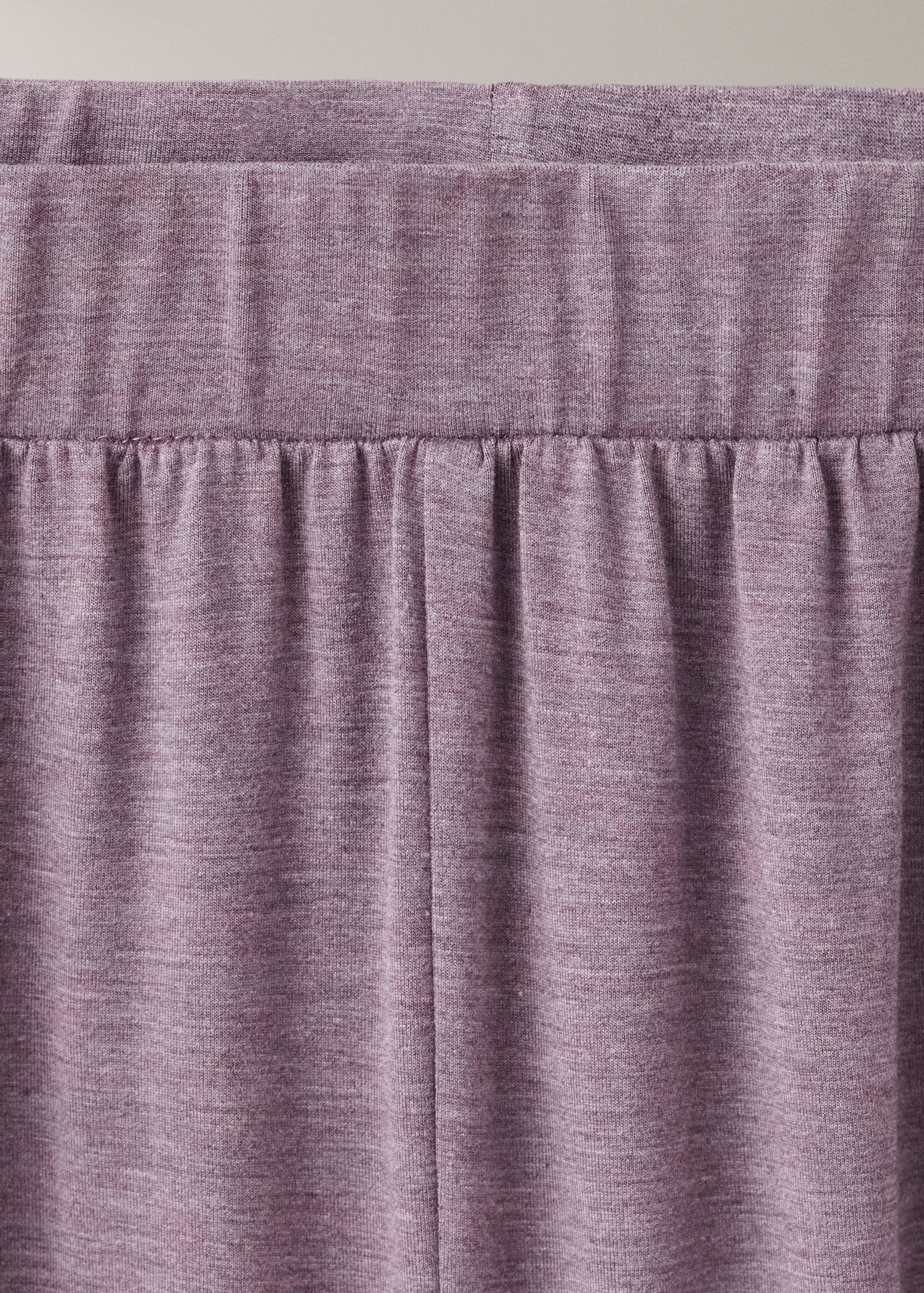 Close-up of mauve pyjama trousers showing the elasticated waistband and soft heathered fabric.