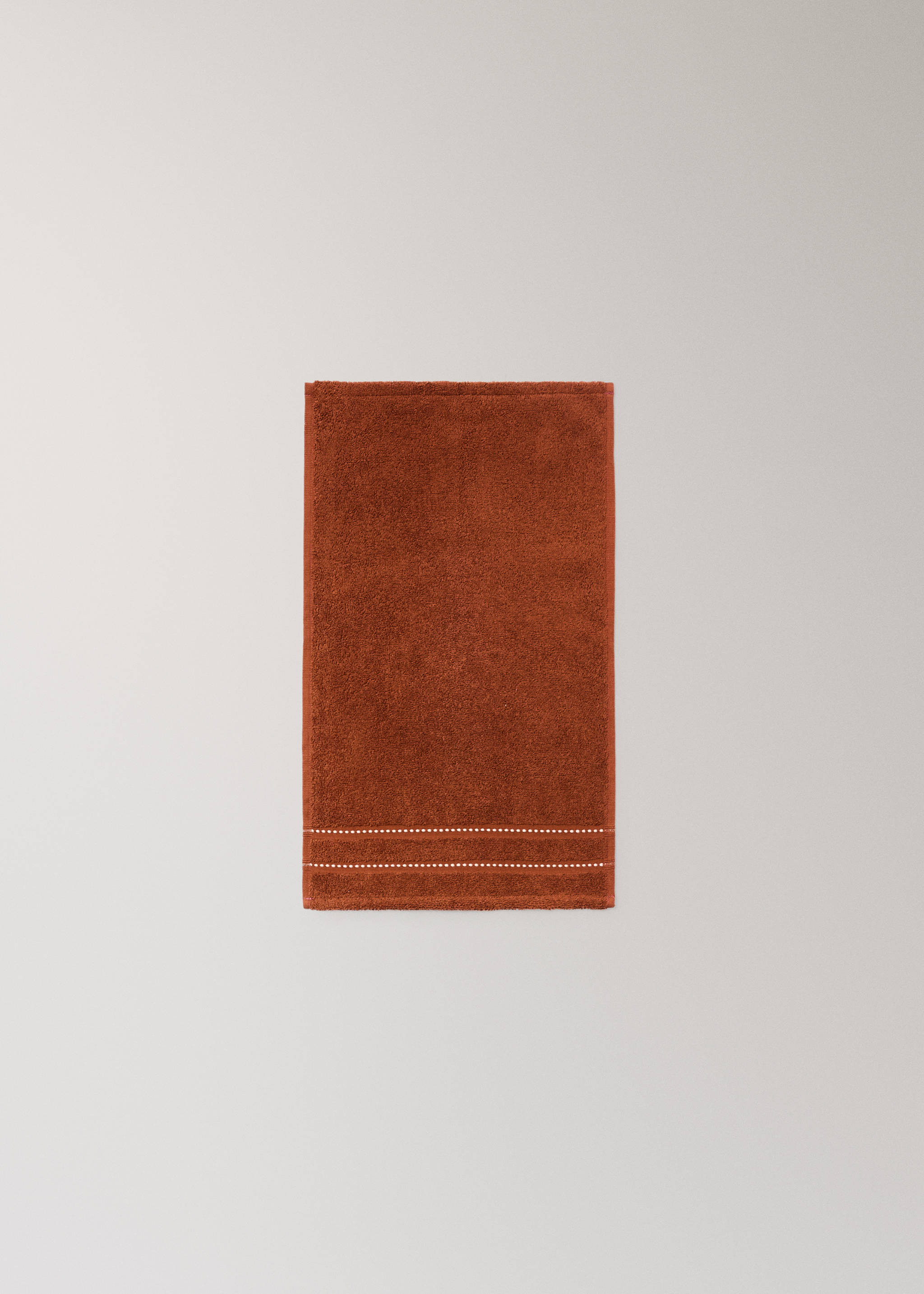 Terracotta towel with white dotted stripes.