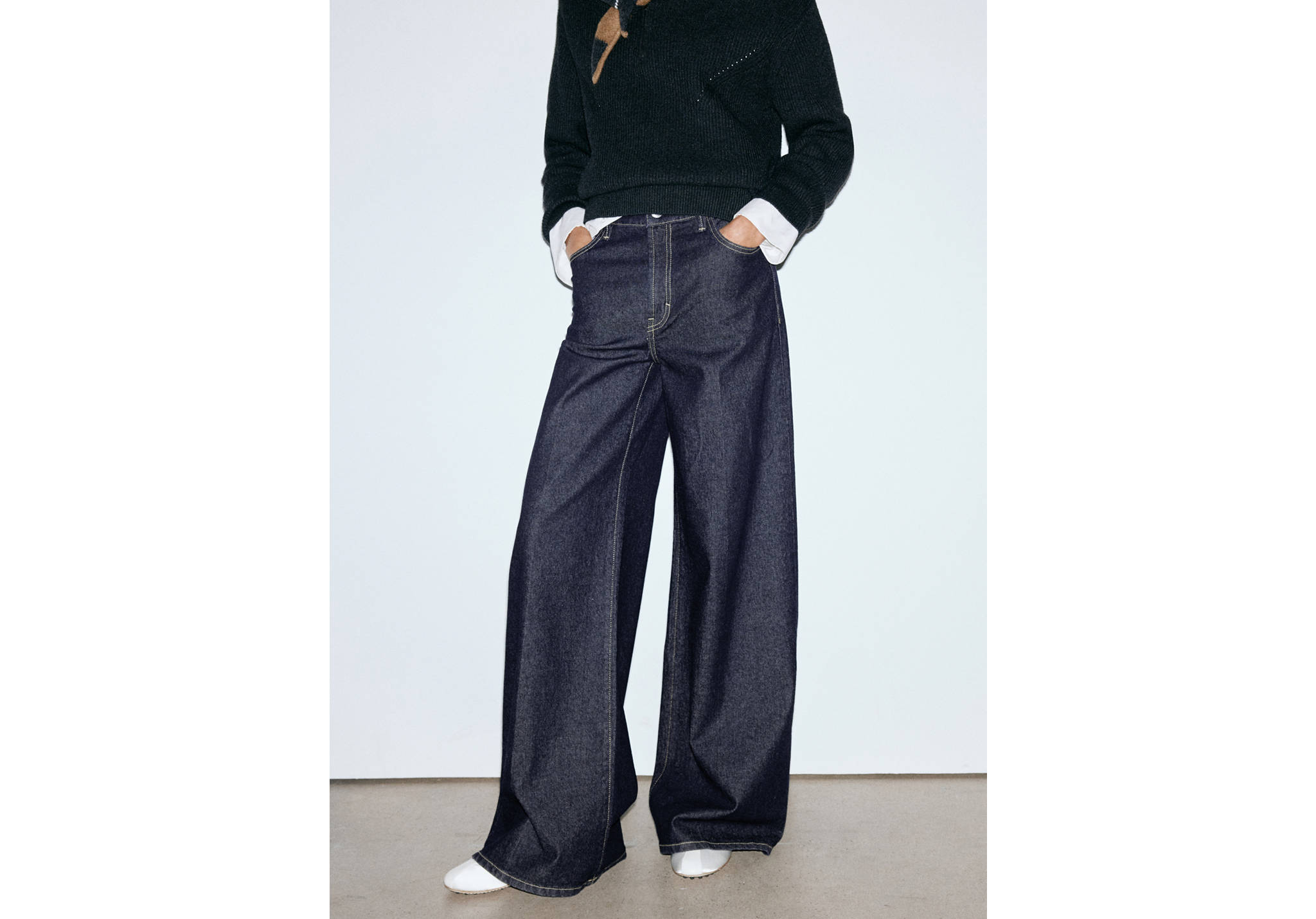 Dark blue wide-leg denim trousers with contrast stitching.