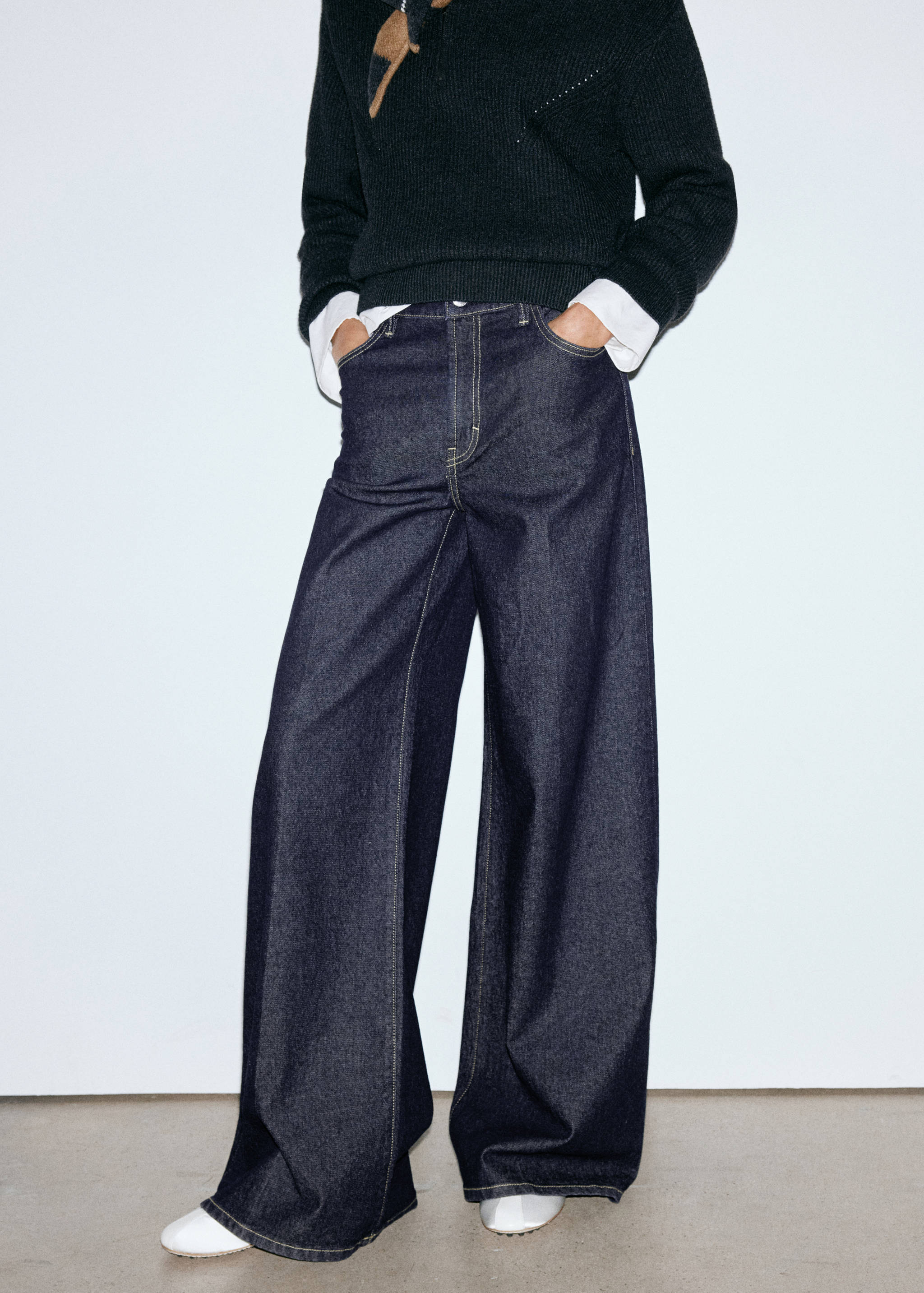 Dark blue wide-leg denim trousers with contrast stitching.