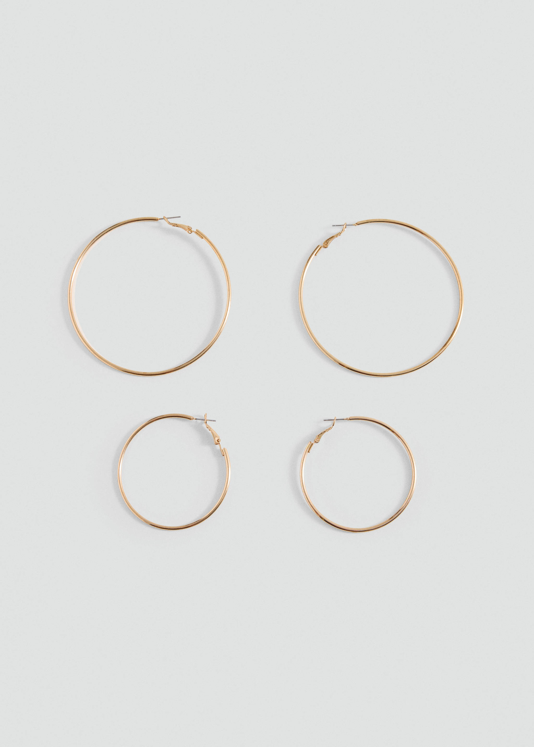 Two pairs of gold-toned metal hoop earrings in different sizes.