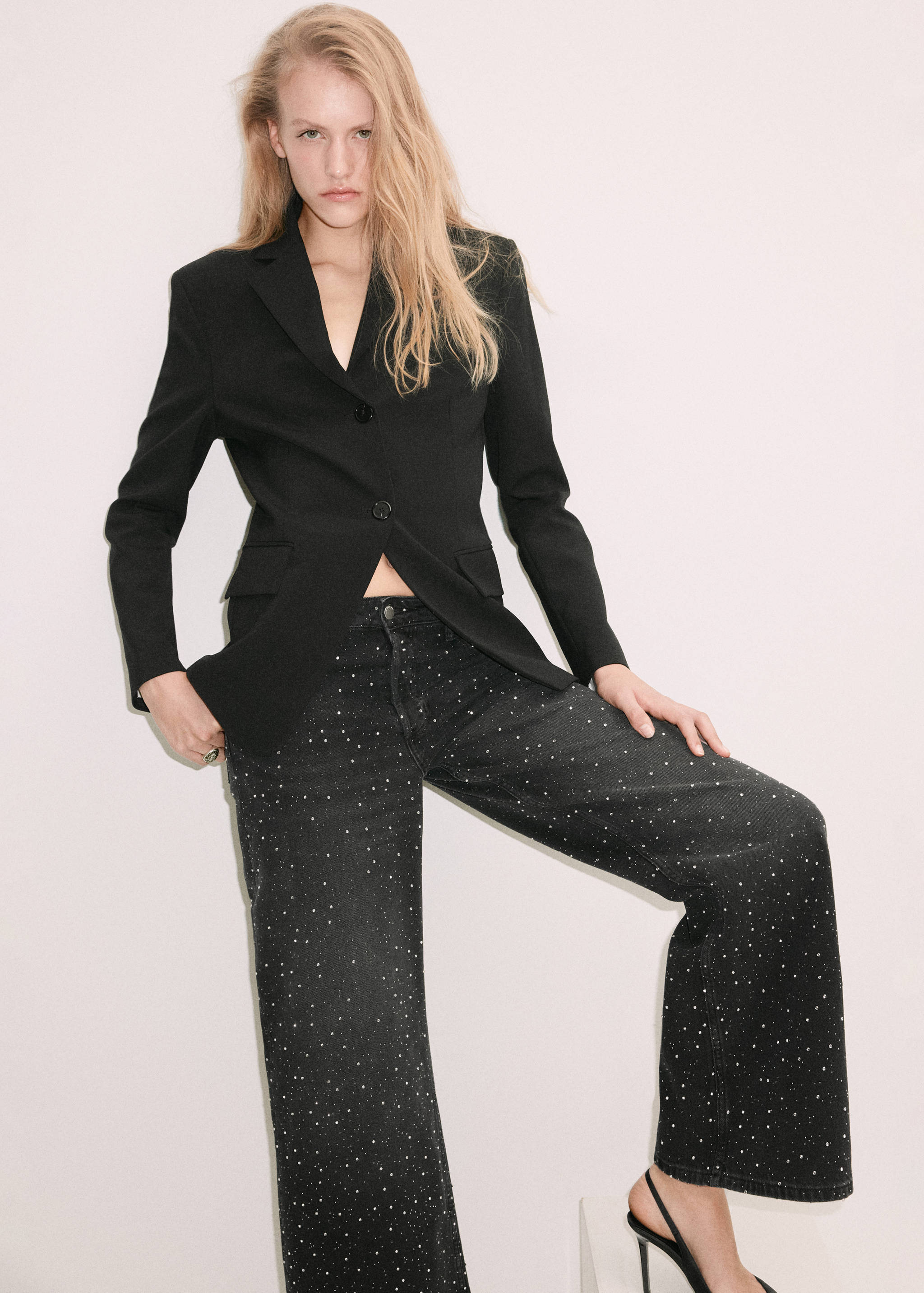Black rhinestone-embellished denim trousers worn with a black blazer.