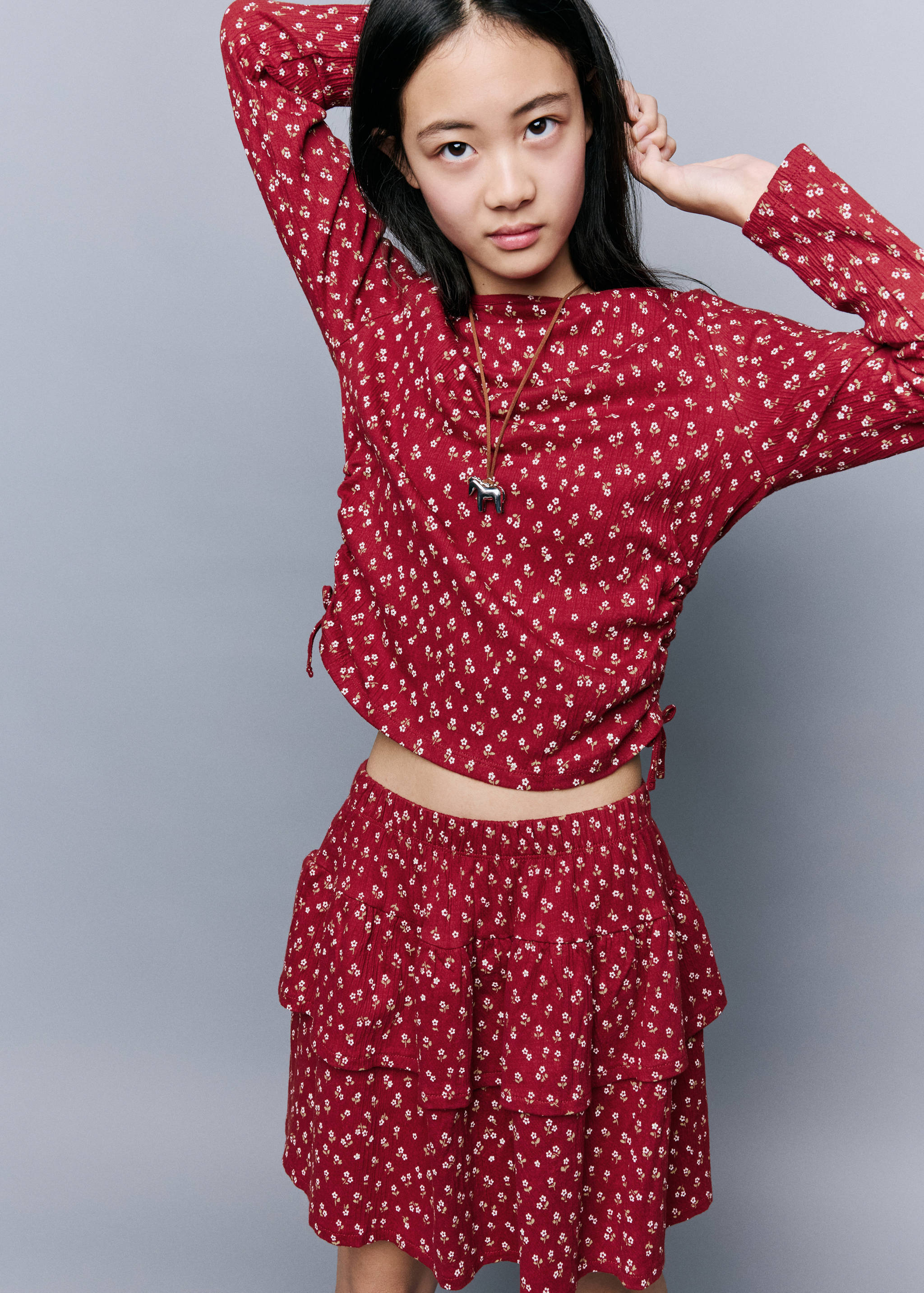Red floral long-sleeved t-shirt with boat neckline and side ties.
