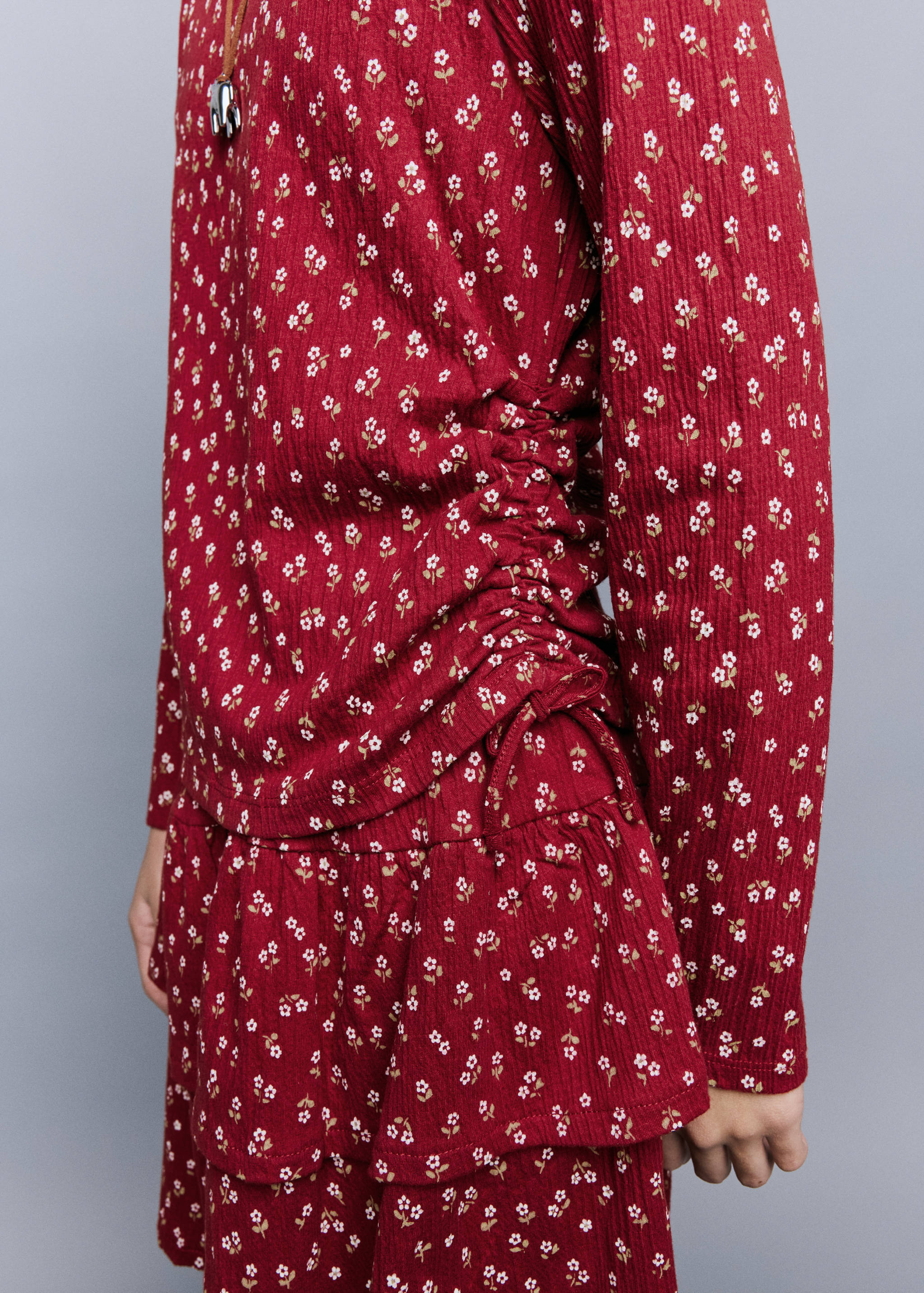 Red floral long-sleeve t-shirt with side ruching and drawstring detail.