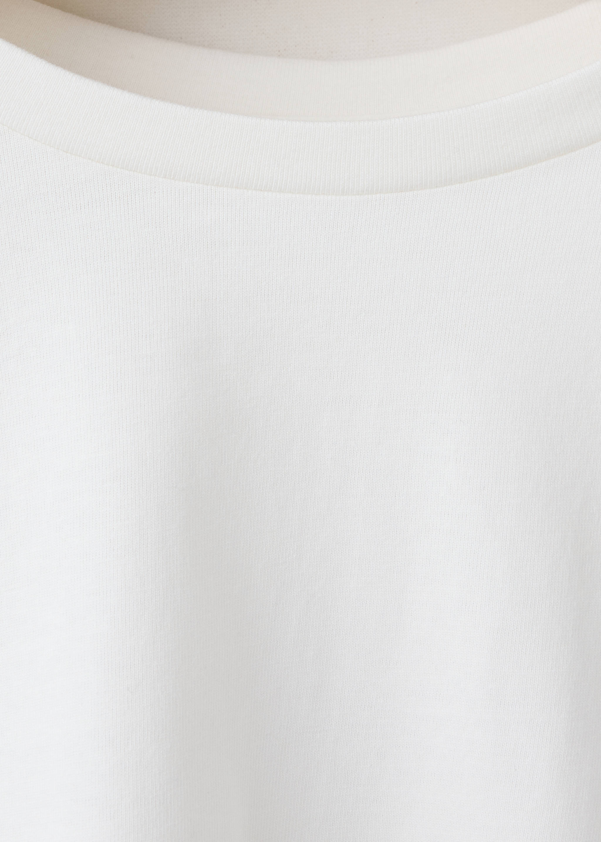 Close-up of a white children's t-shirt with a ribbed crew neck.