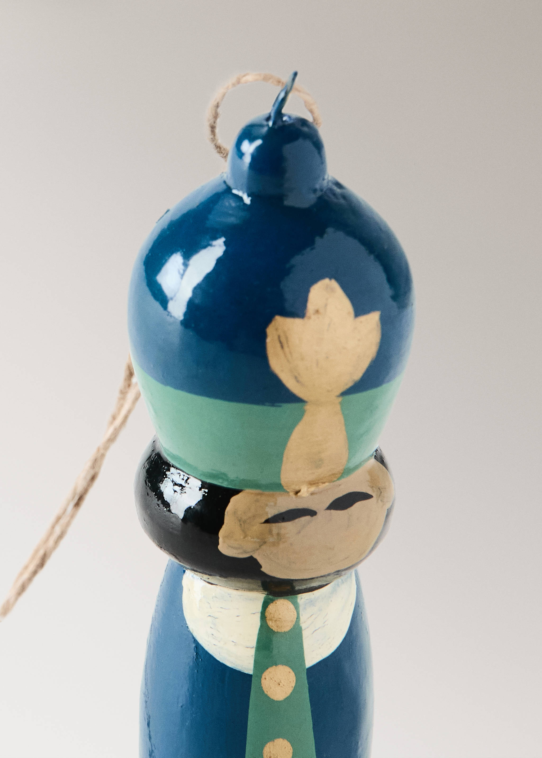 Blue and green painted wooden Christmas ornament with a hanging twine.