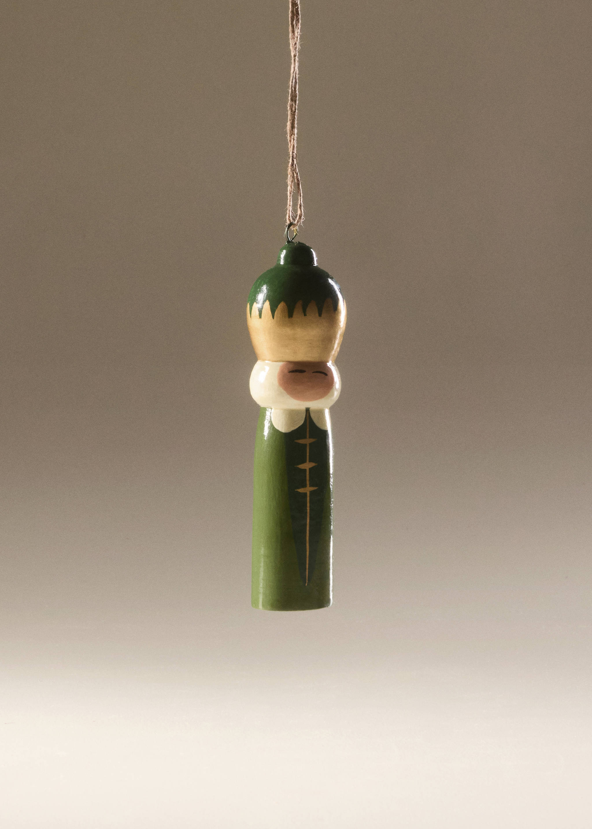 Green and gold wooden Christmas ornament hanging by twine.