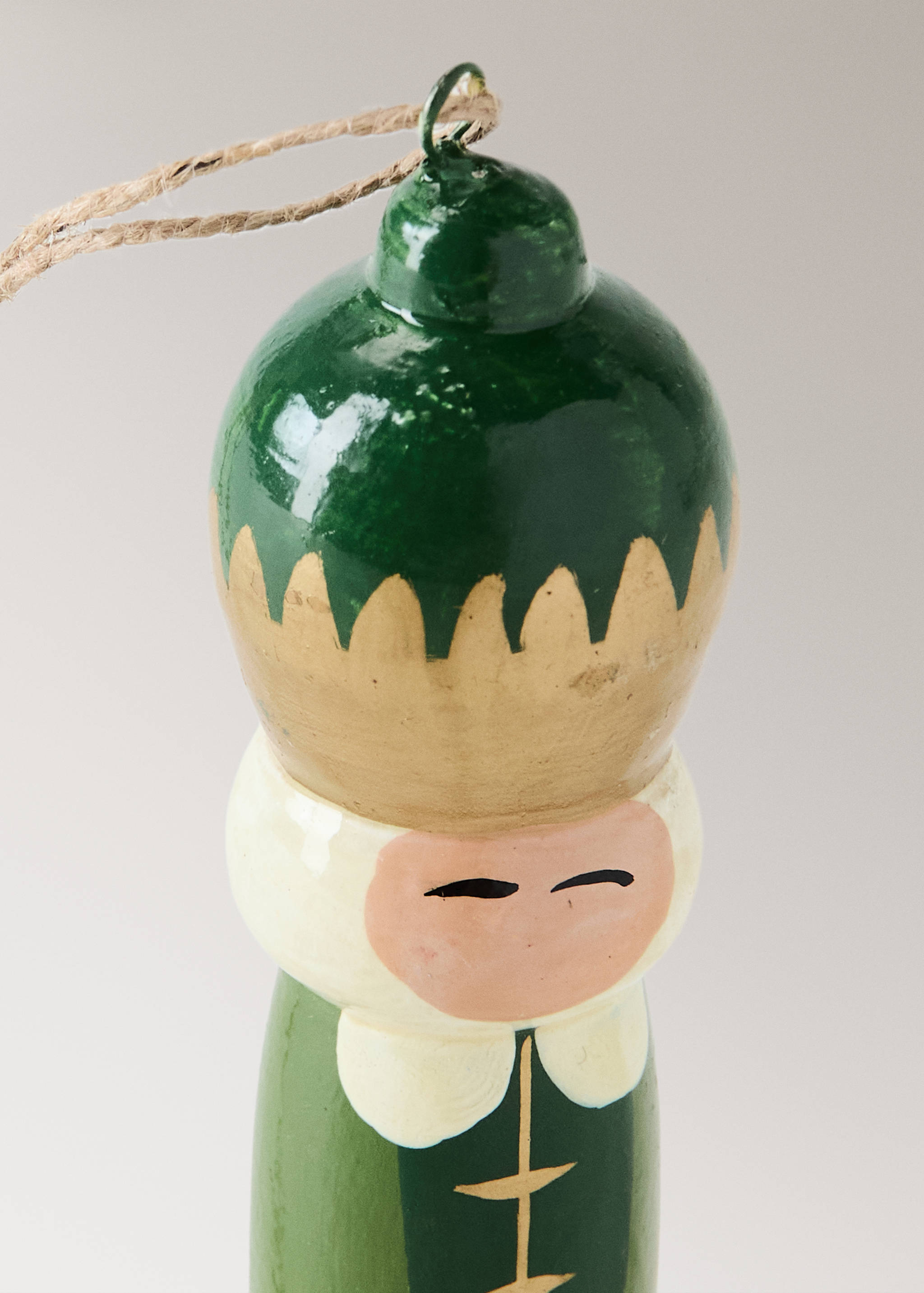 Green and gold painted wooden Christmas ornament detail with twine.