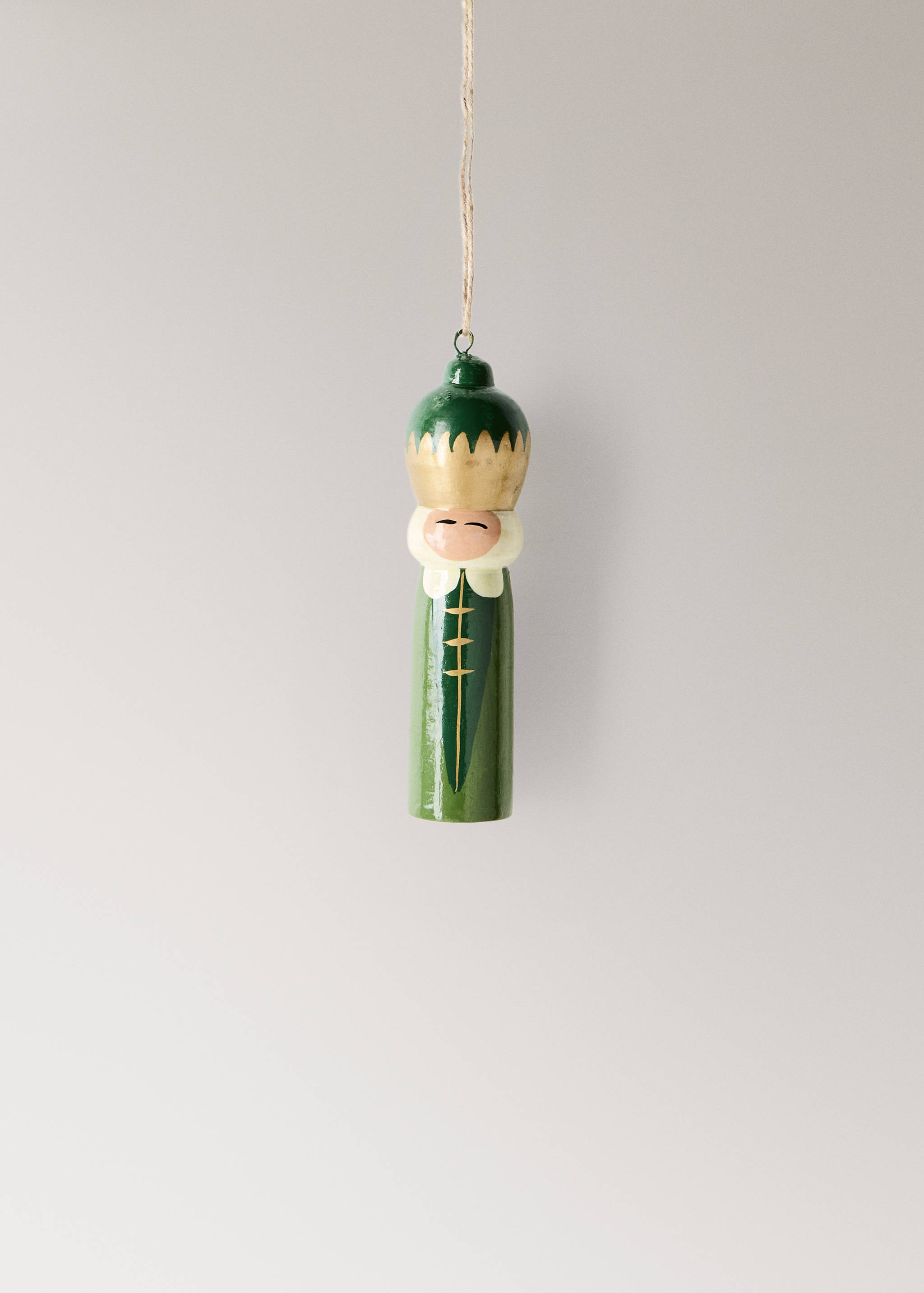 Green and gold painted wooden king Christmas ornament hanging on twine.