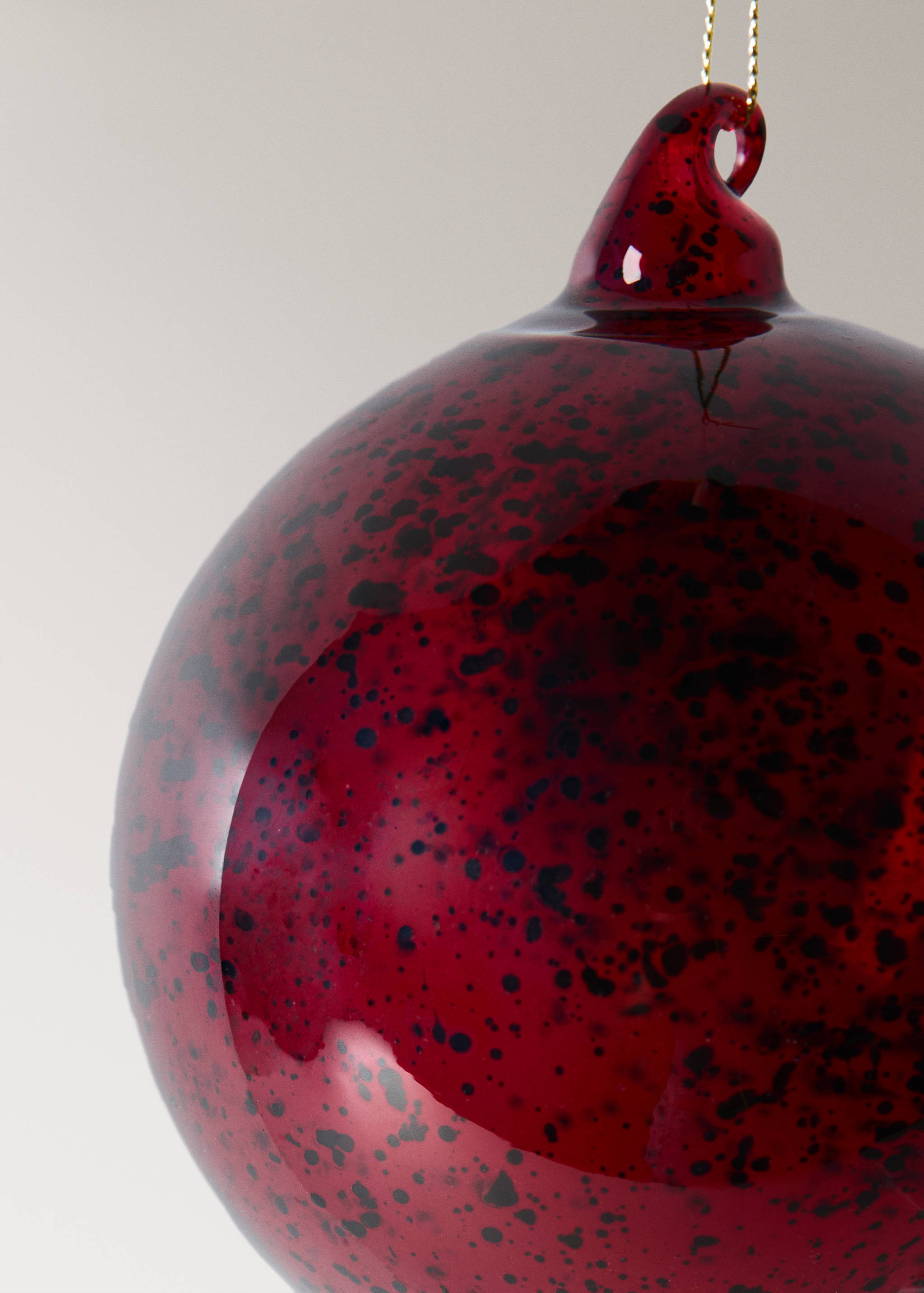 Dark red speckled glass Christmas ornament with a hanging loop.