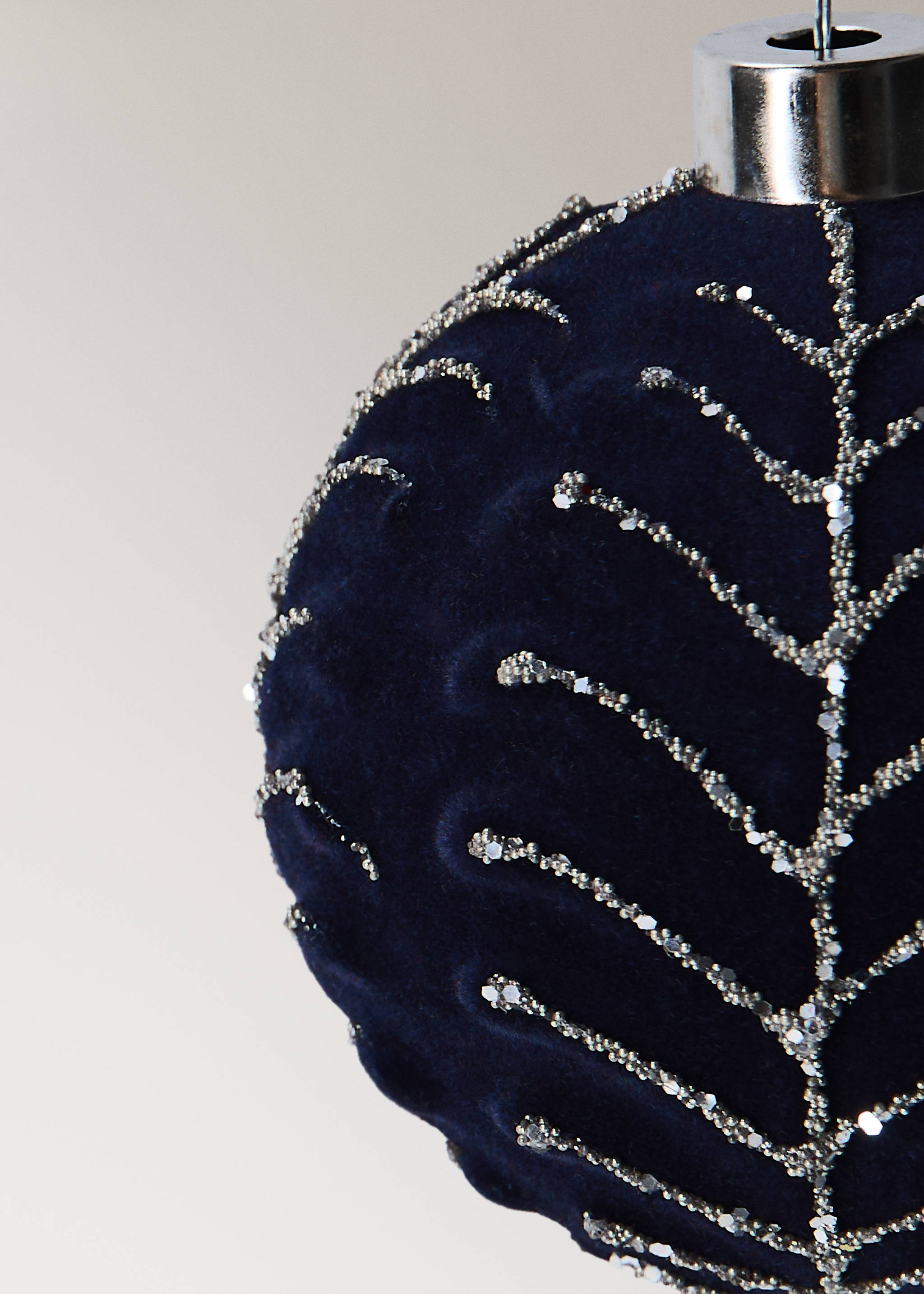 Dark blue velvet Christmas bauble with silver glitter leaf pattern and metallic cap.