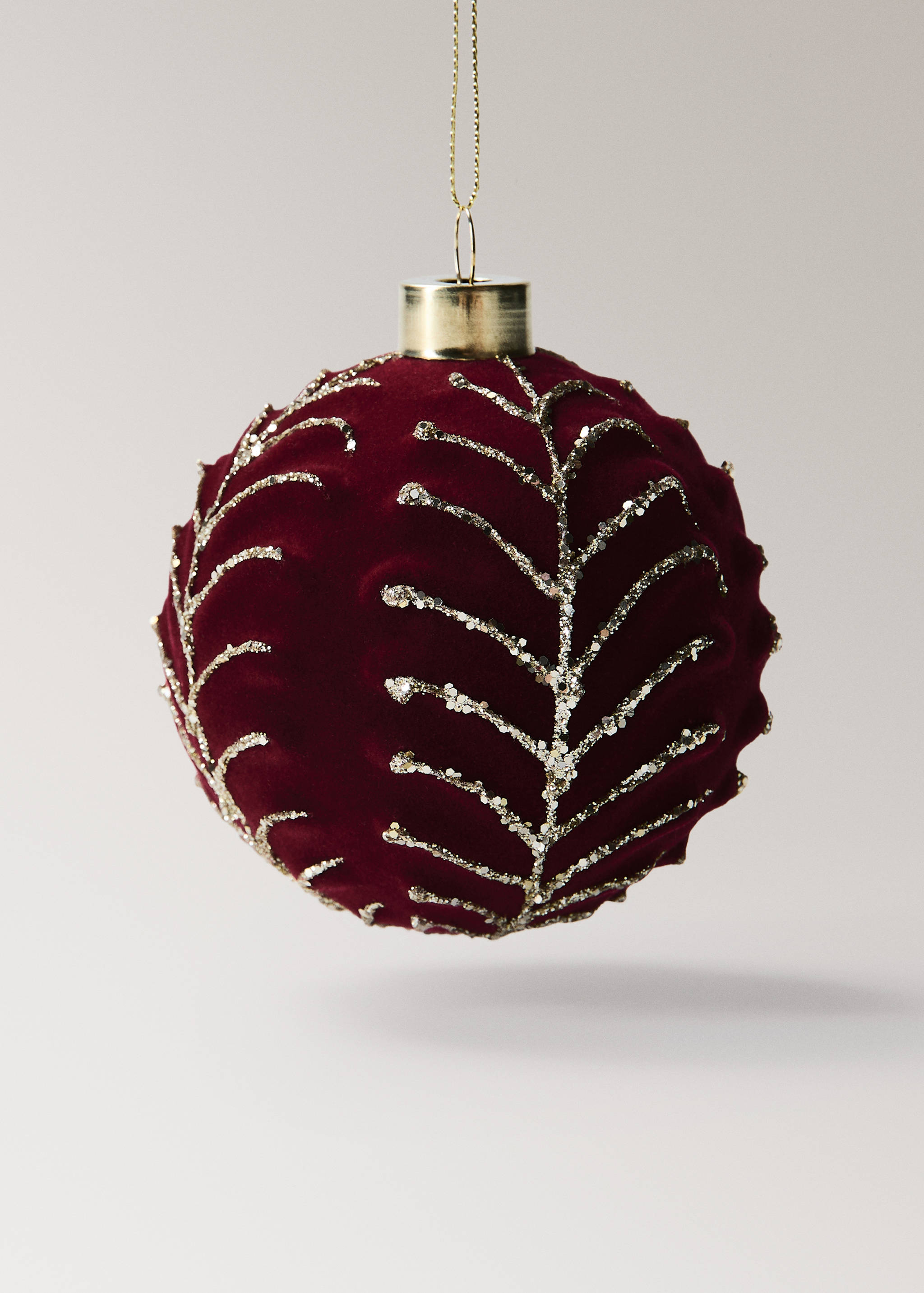 Red velvet Christmas ornament with gold glitter leaf embroidery.