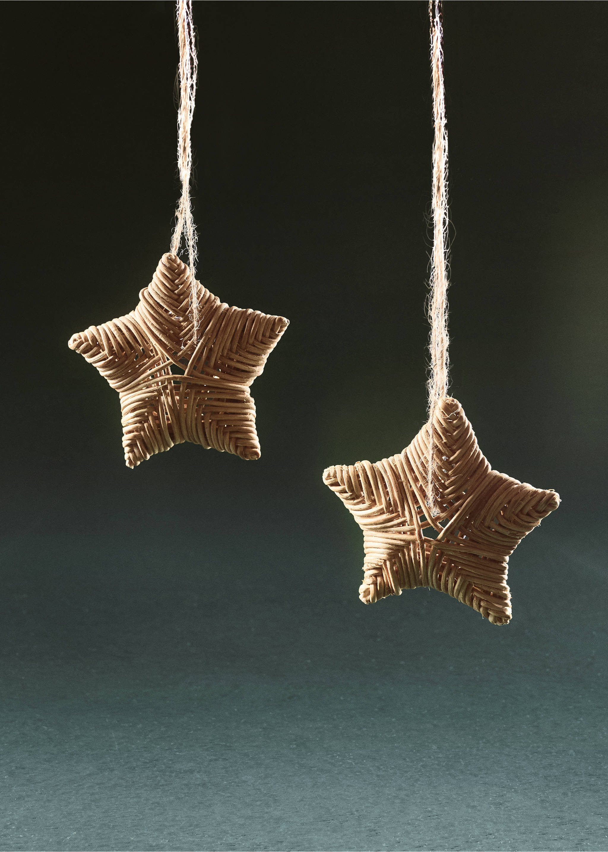 Two woven wicker star Christmas decorations hanging from twine cords., Brown. Ref: 37006749-00.