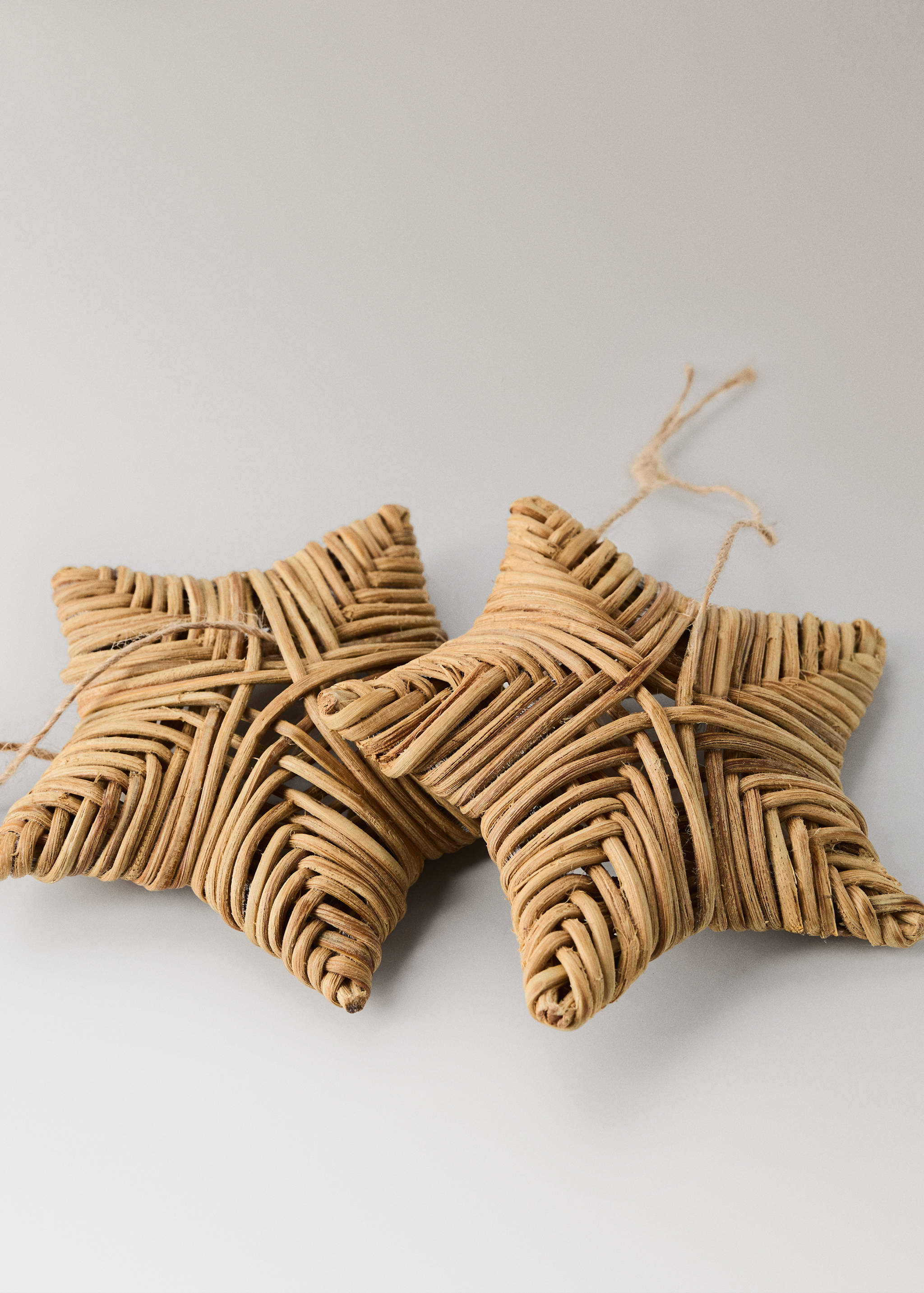 Woven rattan star Christmas ornament with twine hanging loop.