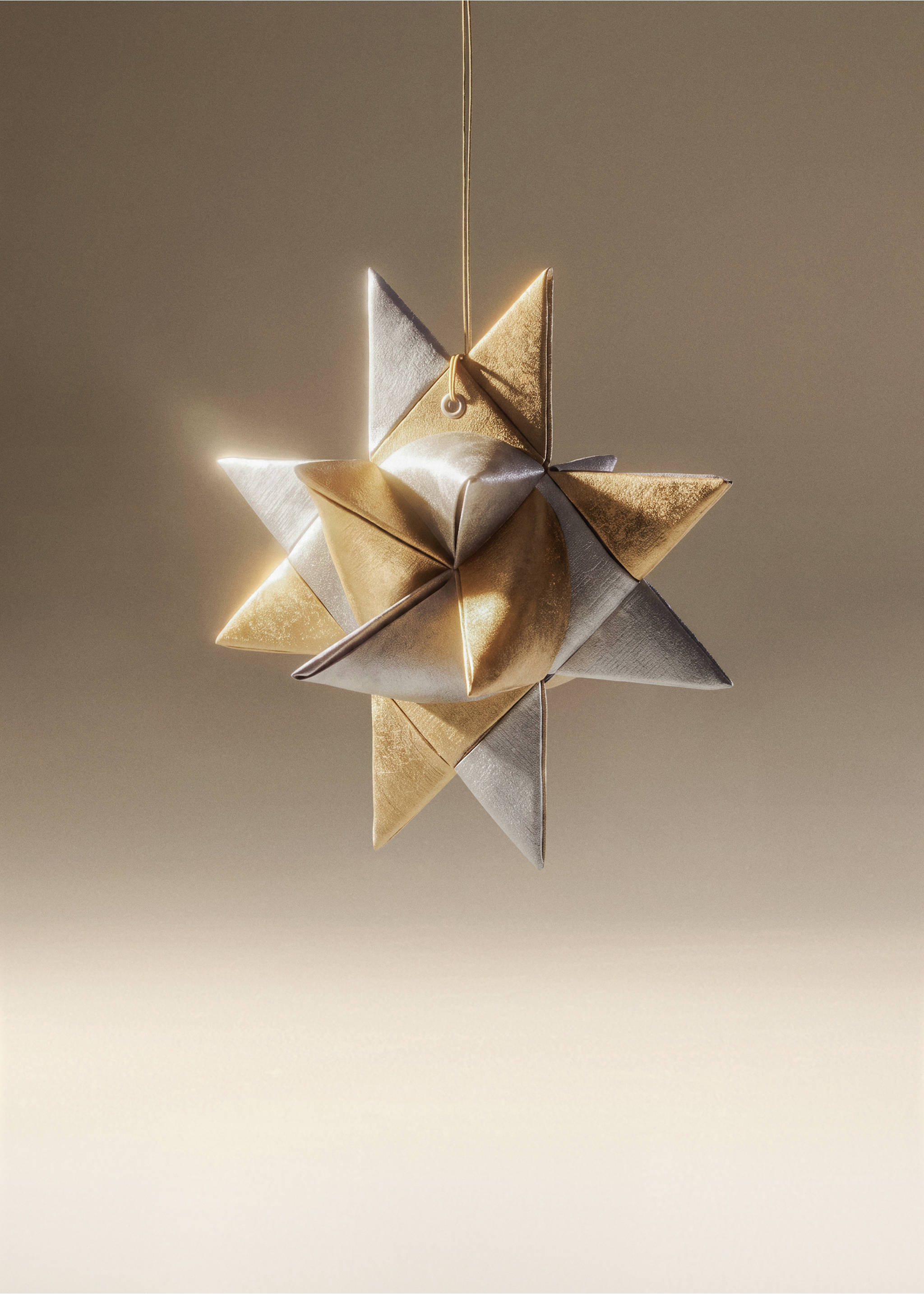 Metallic gold and silver folded star Christmas ornament hanging on a thin gold cord., White. Ref: 37006773-00.