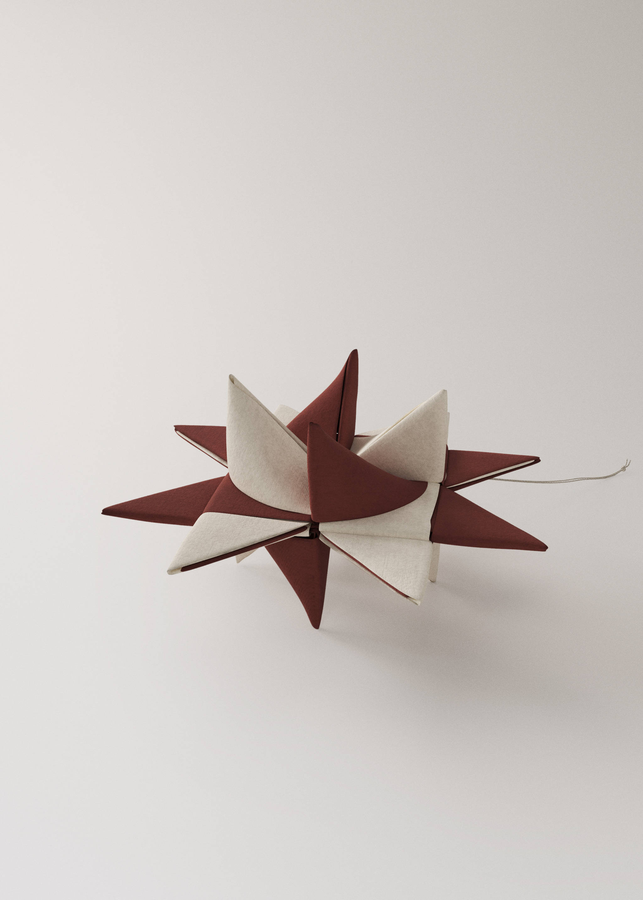 Two folded paper star Christmas ornaments in deep red and white.