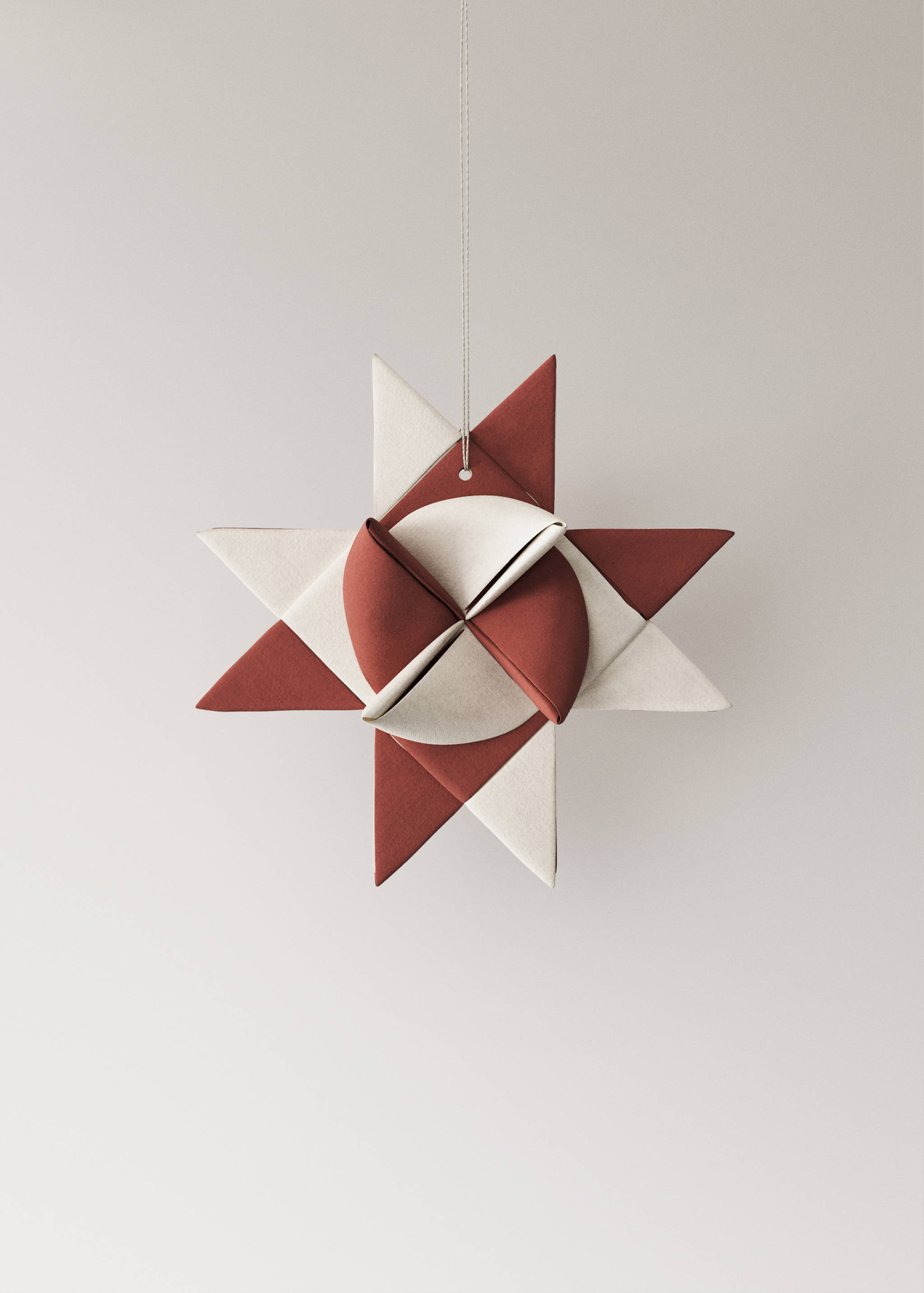 Two hanging red and white geometric star Christmas ornaments.