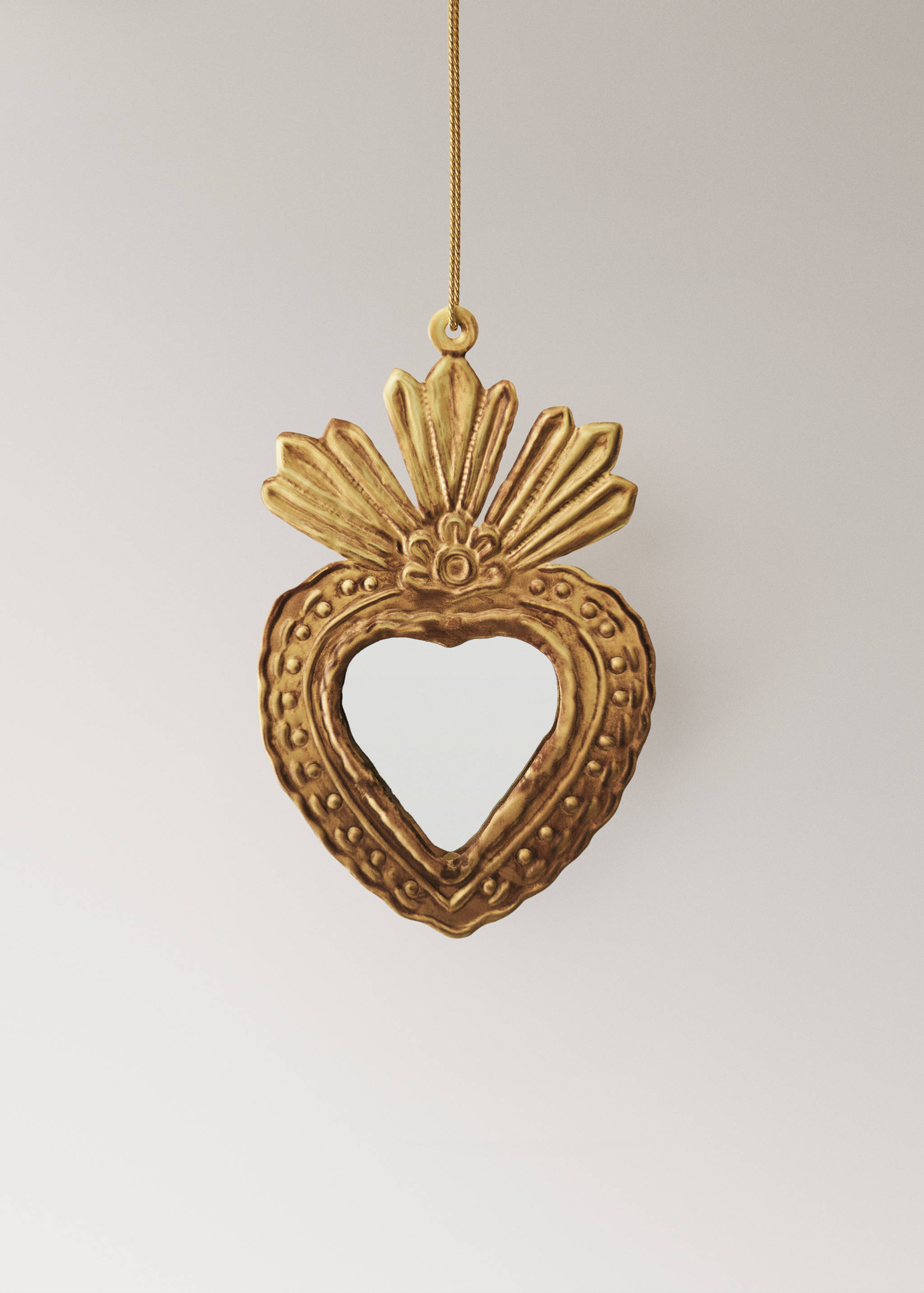 Gold heart-shaped Christmas ornament with sunburst detail.