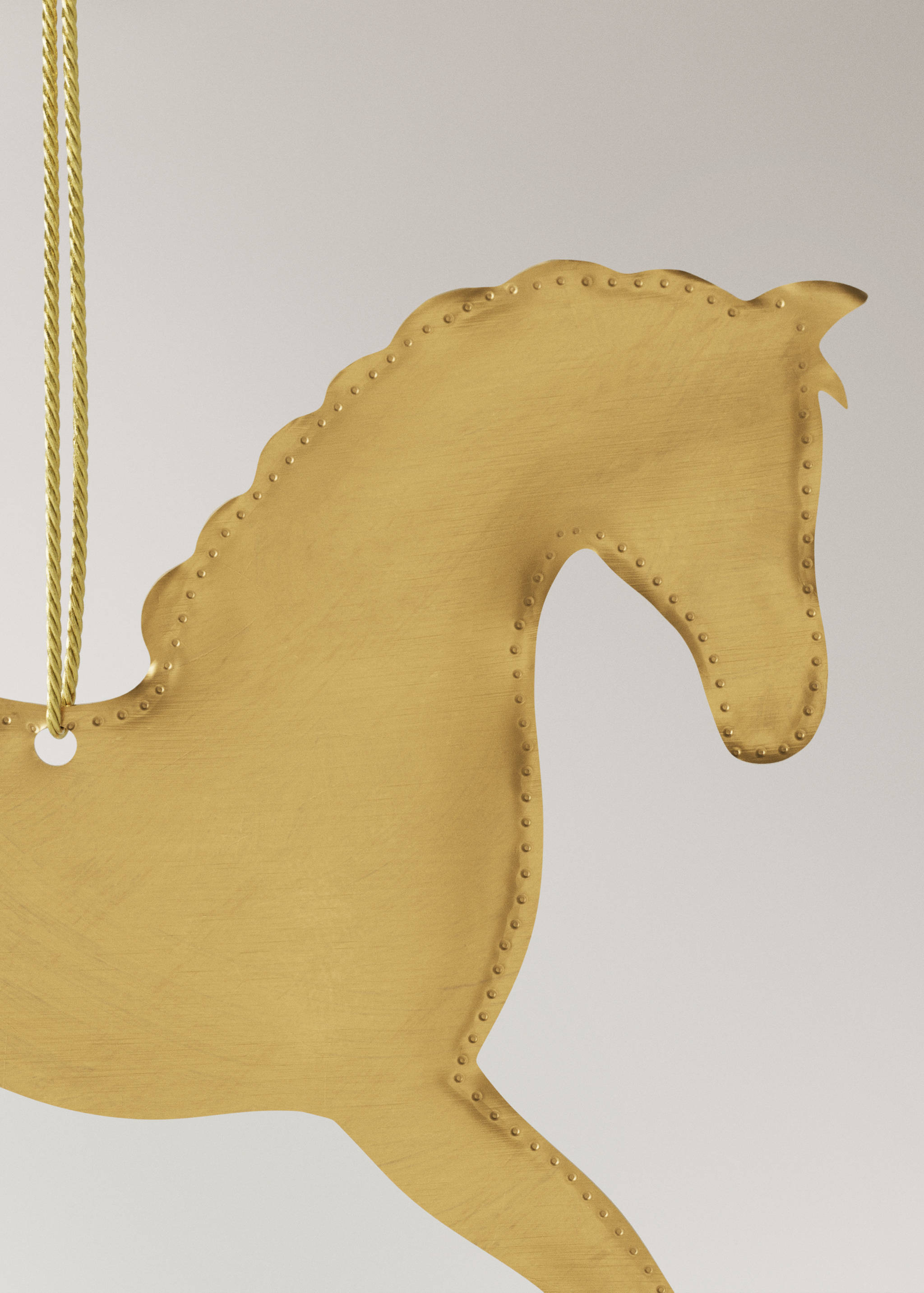 Gold metal horse-shaped Christmas ornament with embossed stud details.