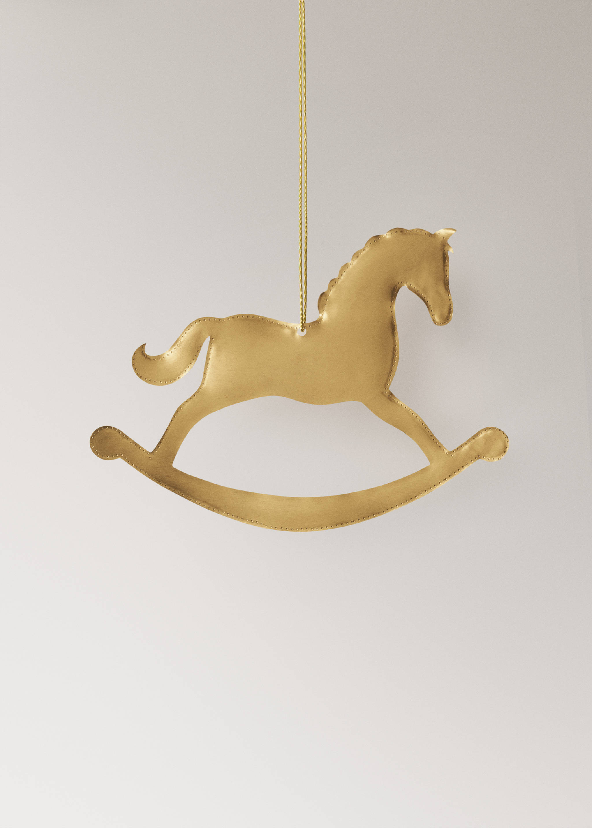 Gold rocking horse Christmas ornament hanging from a thread