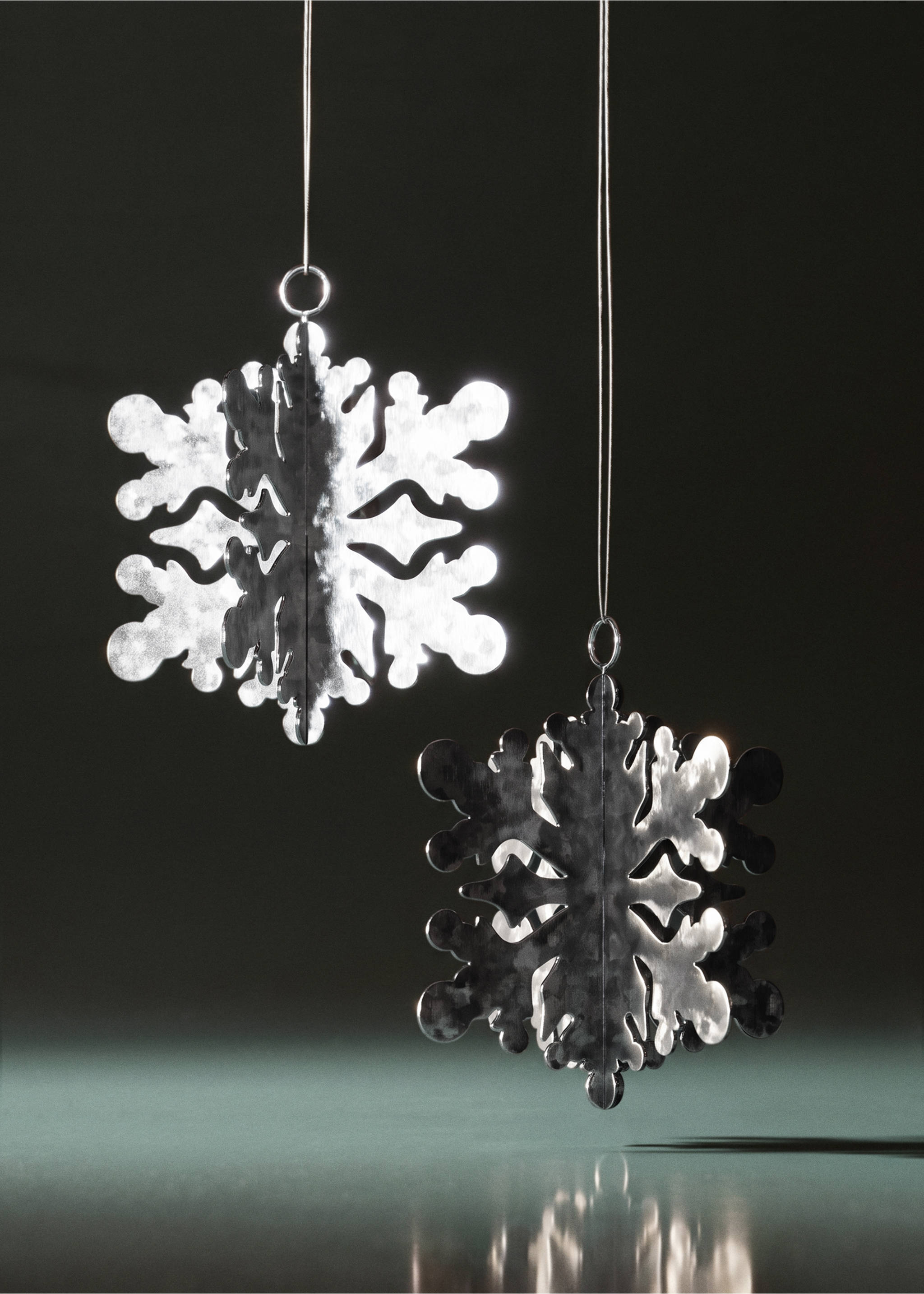 Silver snowflake Christmas ornament with a reflective textured surface hanging by a thin string., Silver. Ref: 37006782-00.