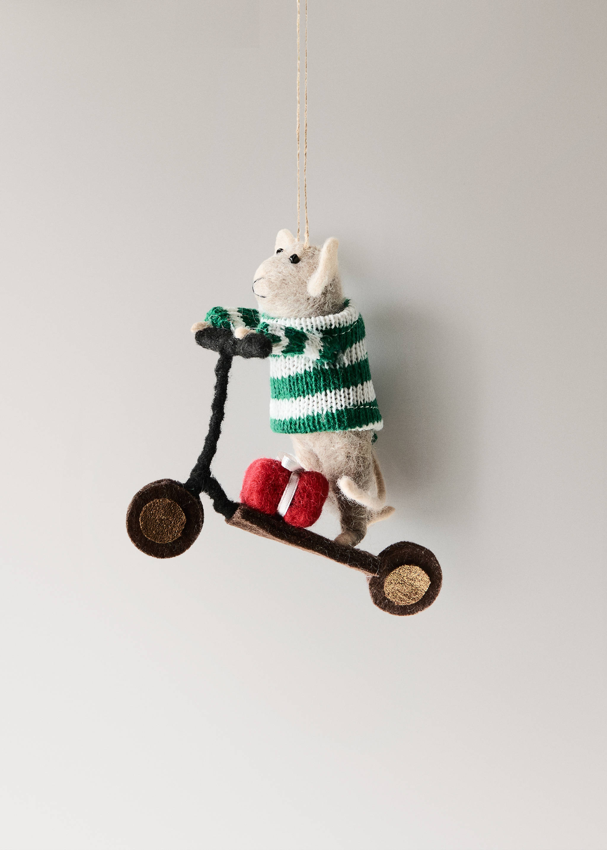 Adorno de Navidad de ratón de fieltro con jersey de rayas montado en un patinete.