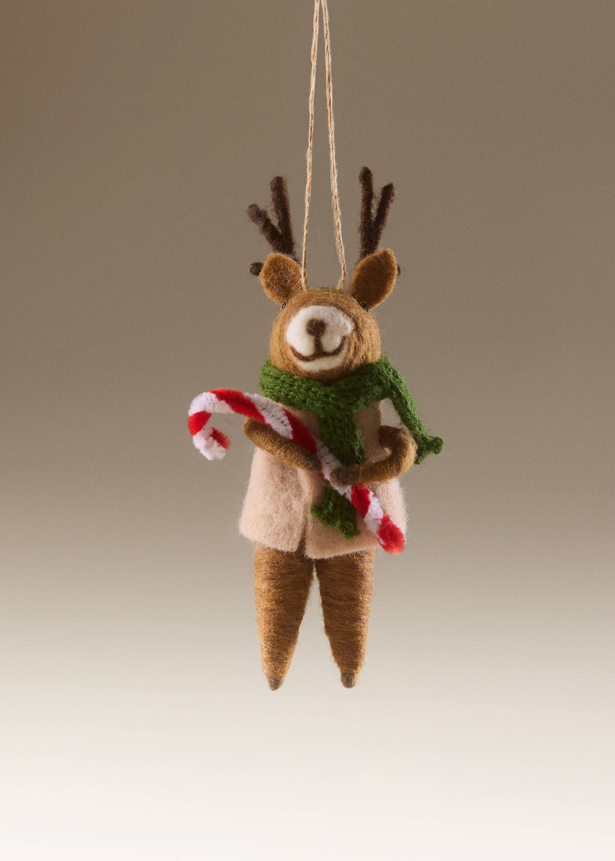 Felt reindeer Christmas ornament holding a candy cane and wearing a scarf.