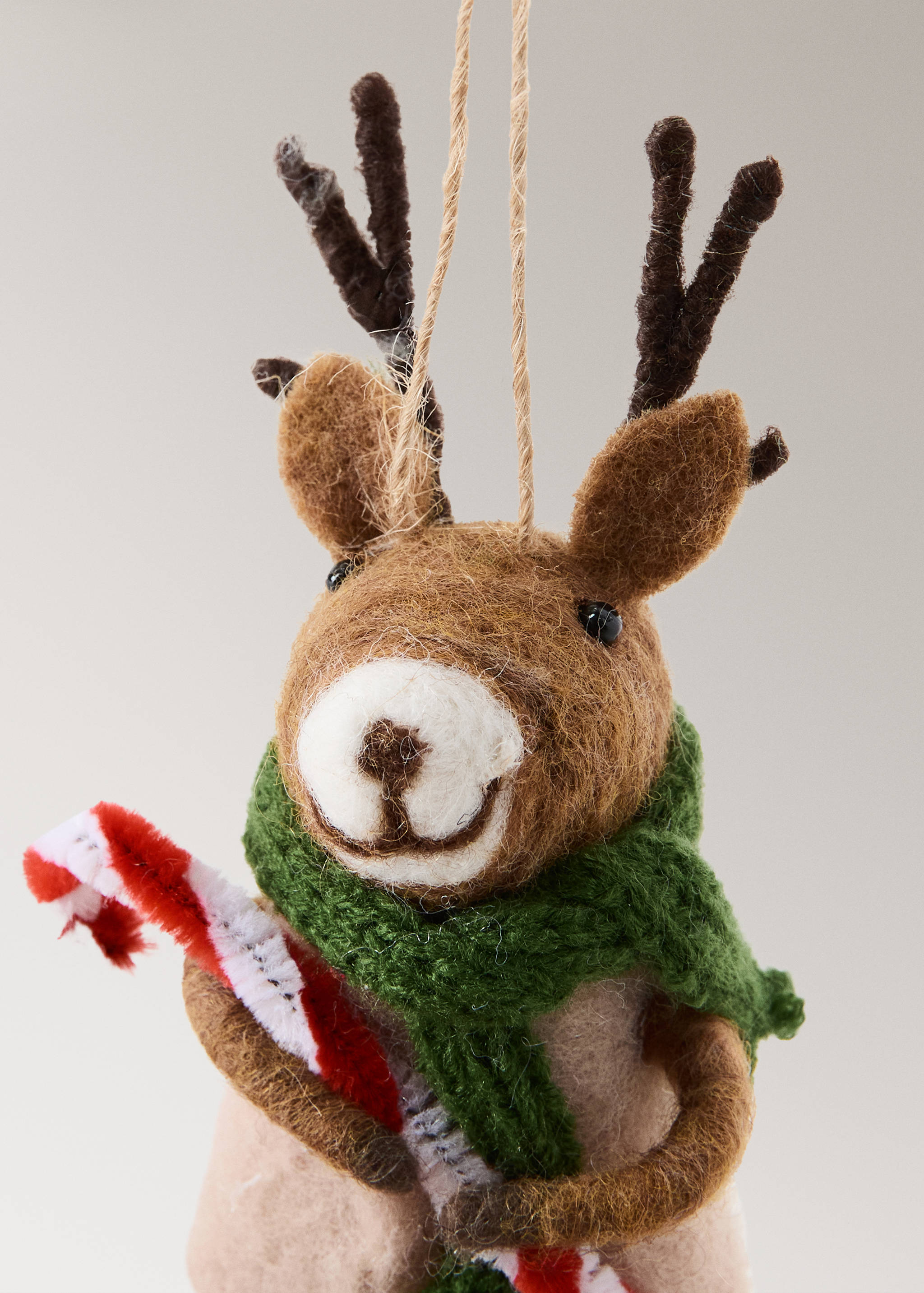 Felt reindeer Christmas ornament with a green scarf and candy cane.
