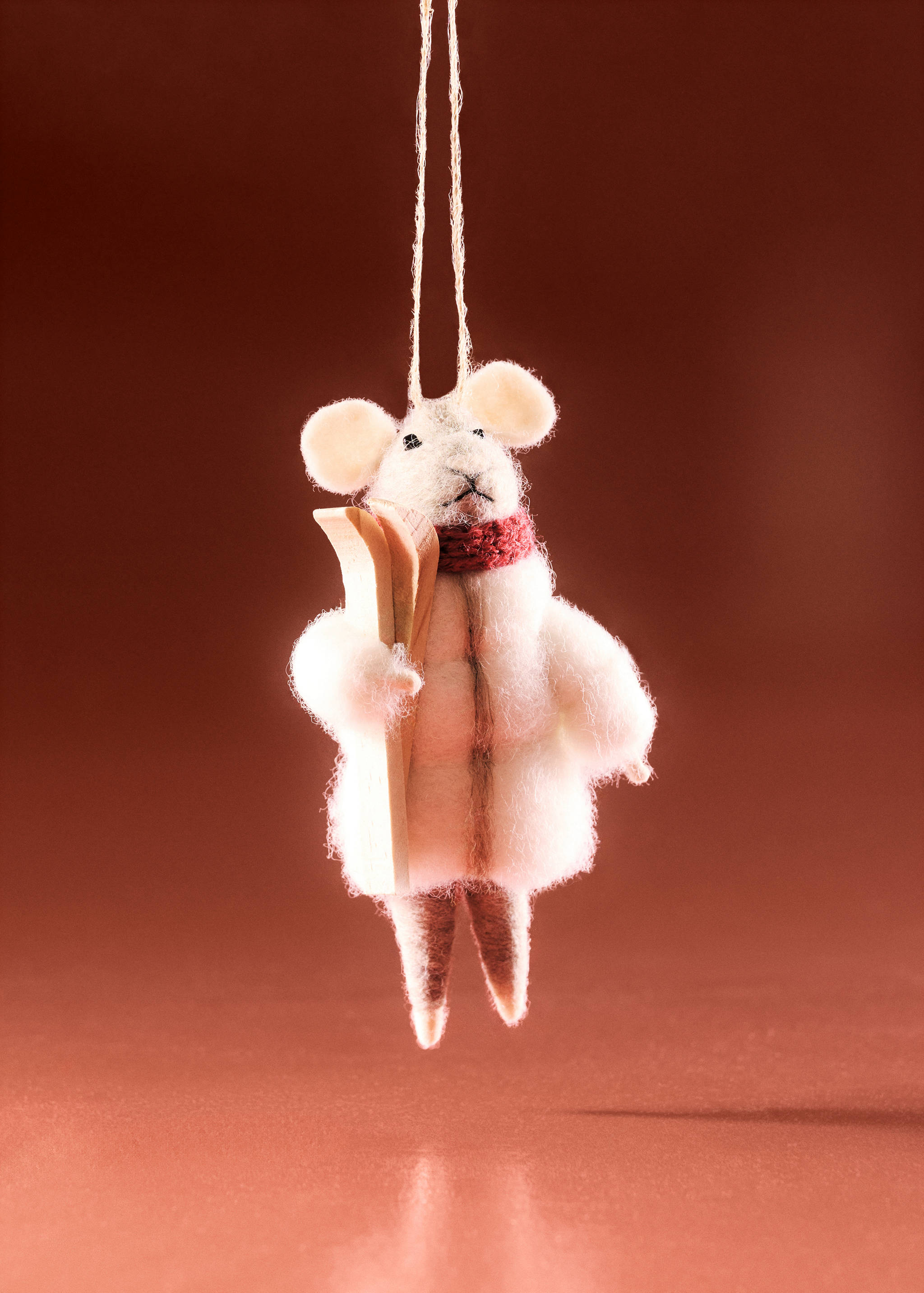 Felt mouse Christmas ornament wearing a puffer coat and skis.
