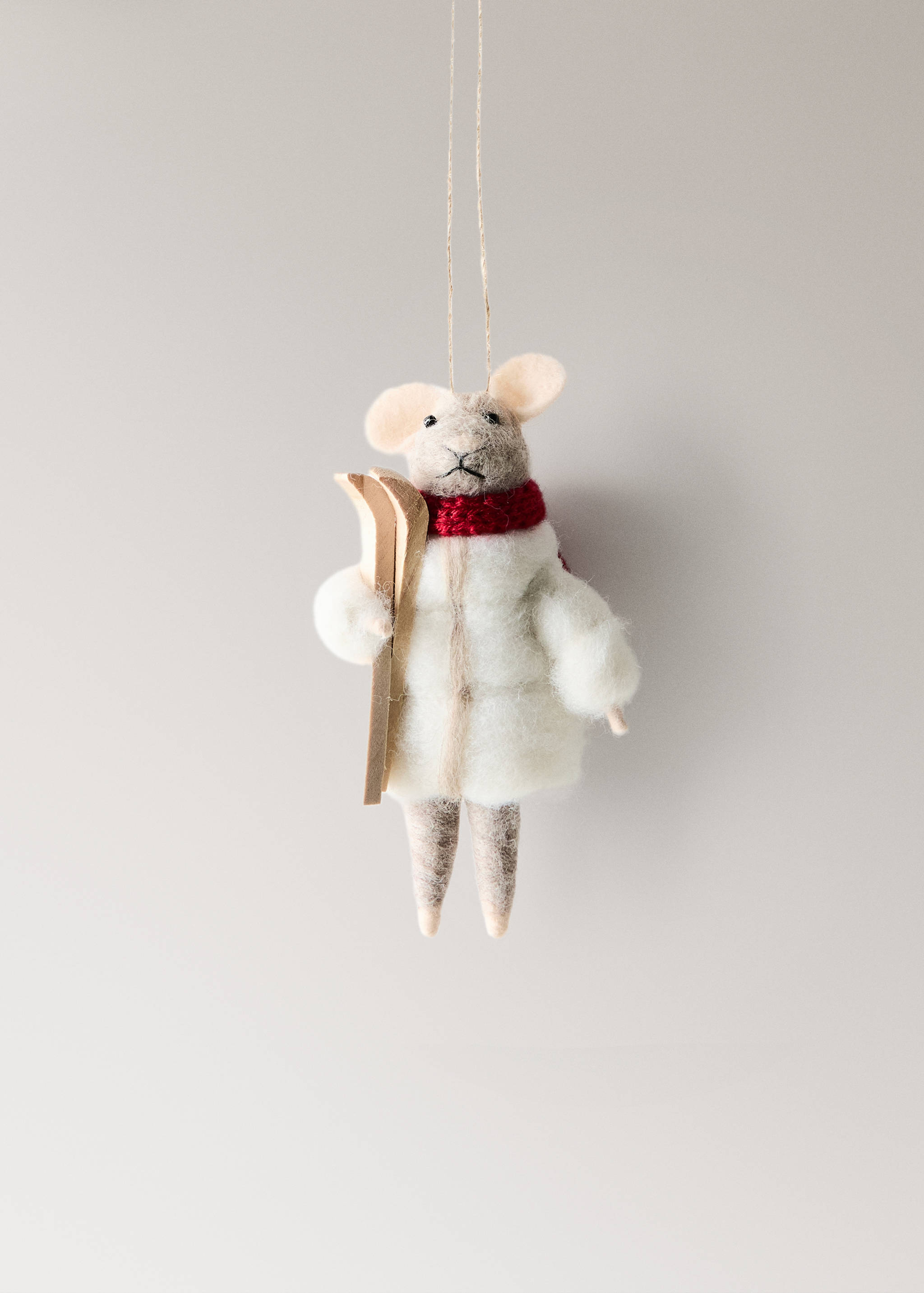 Felt mouse Christmas ornament wearing a white puffer jacket, red scarf, and holding wooden skis.