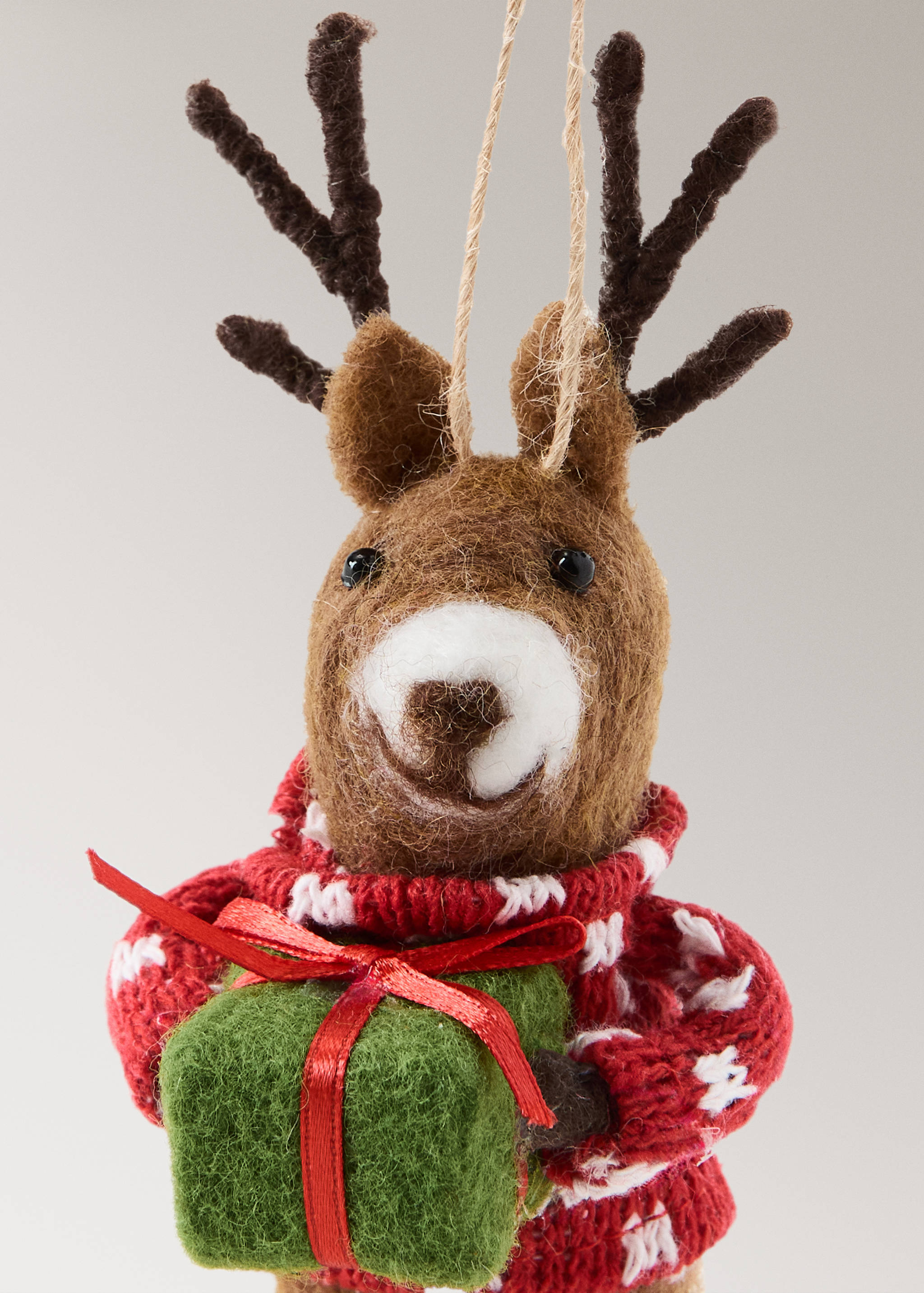 Felt reindeer Christmas ornament holding a green gift box and wearing a red Nordic pattern jumper.
