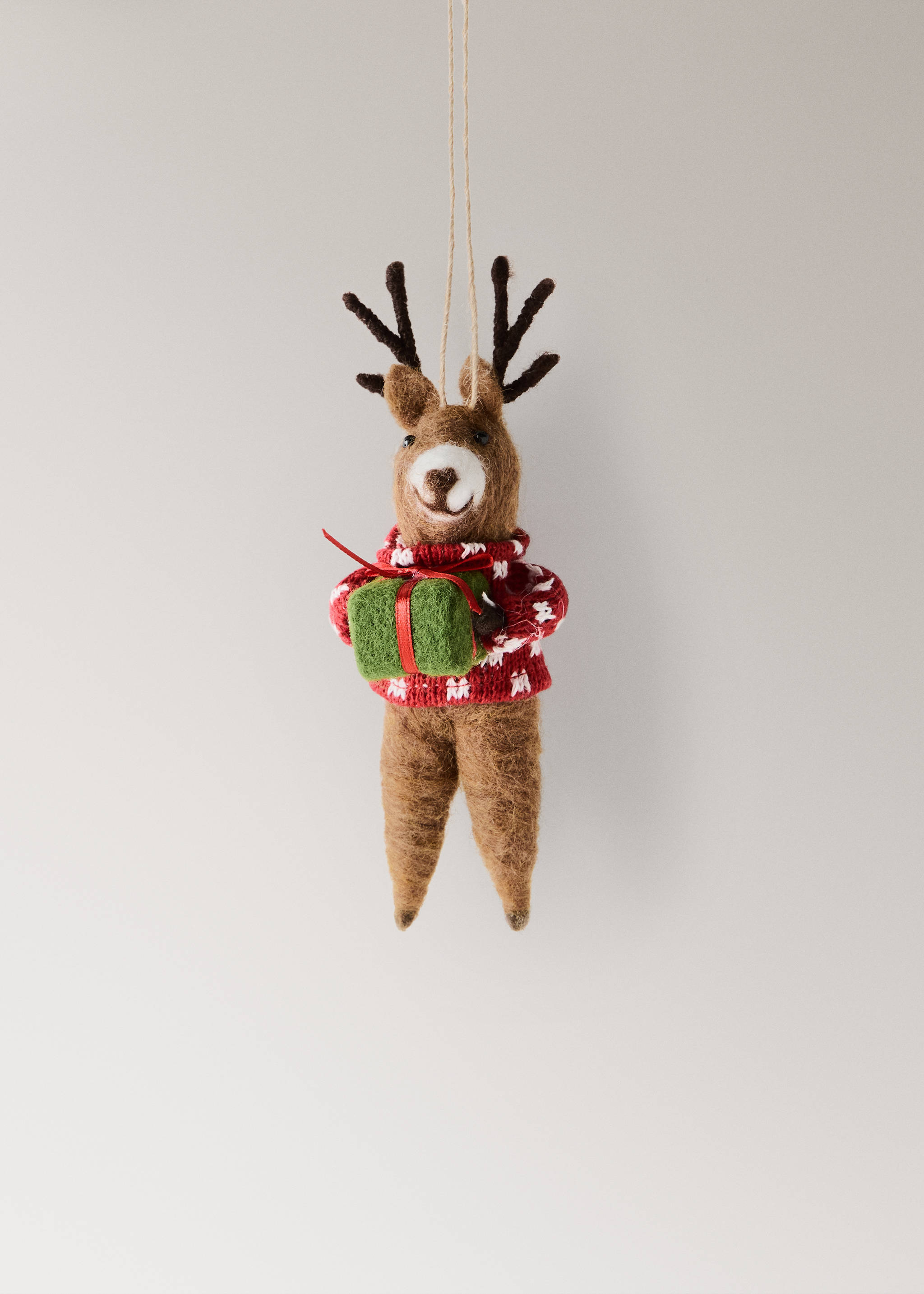 Brown felt reindeer Christmas ornament in a red fair-isle sweater holding a green gift.