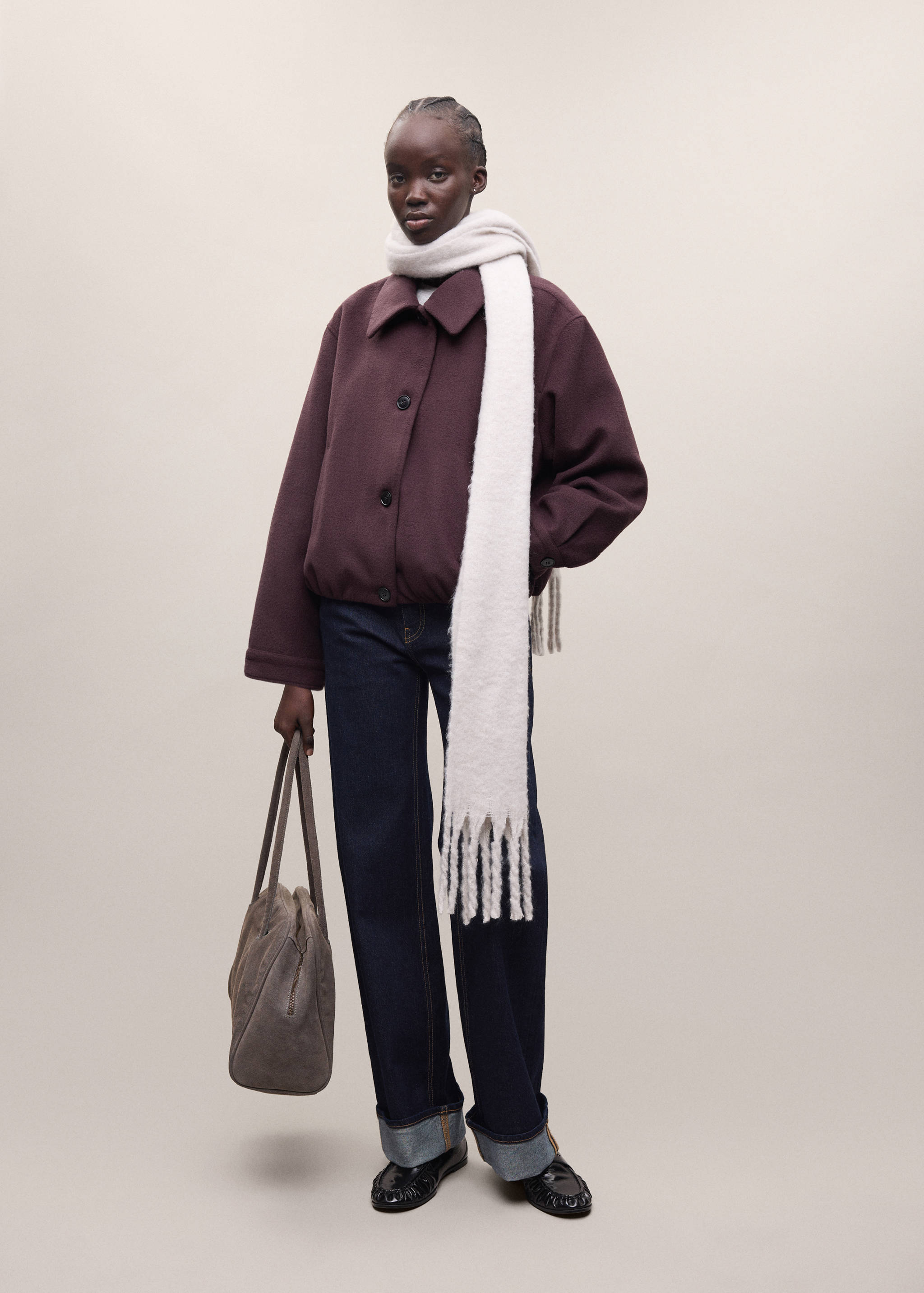 Burgundy coat with classic collar and front buttons, styled with wide-leg trousers, cream scarf, and handbag.