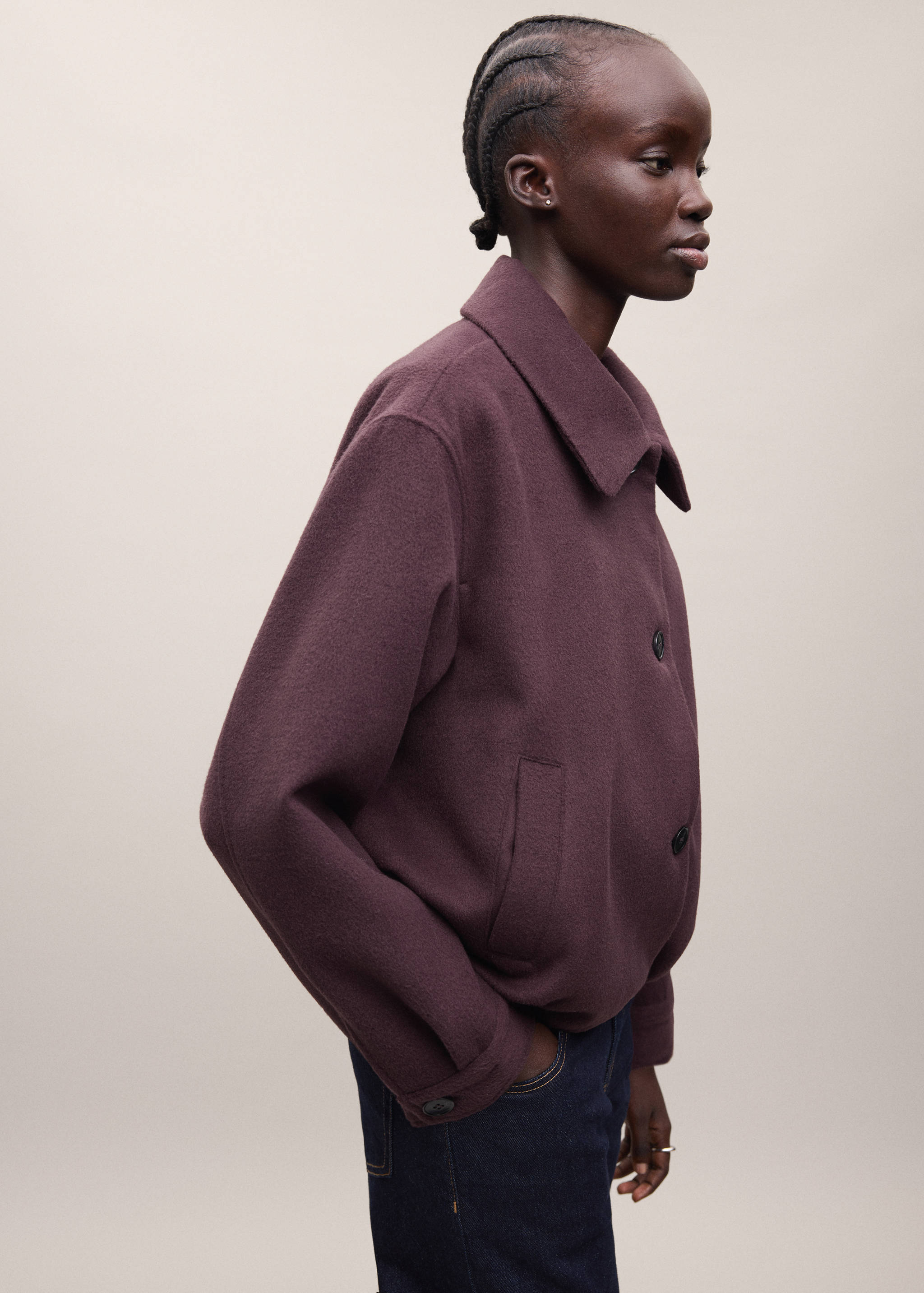 Burgundy coat with a pointed collar and button fastening.