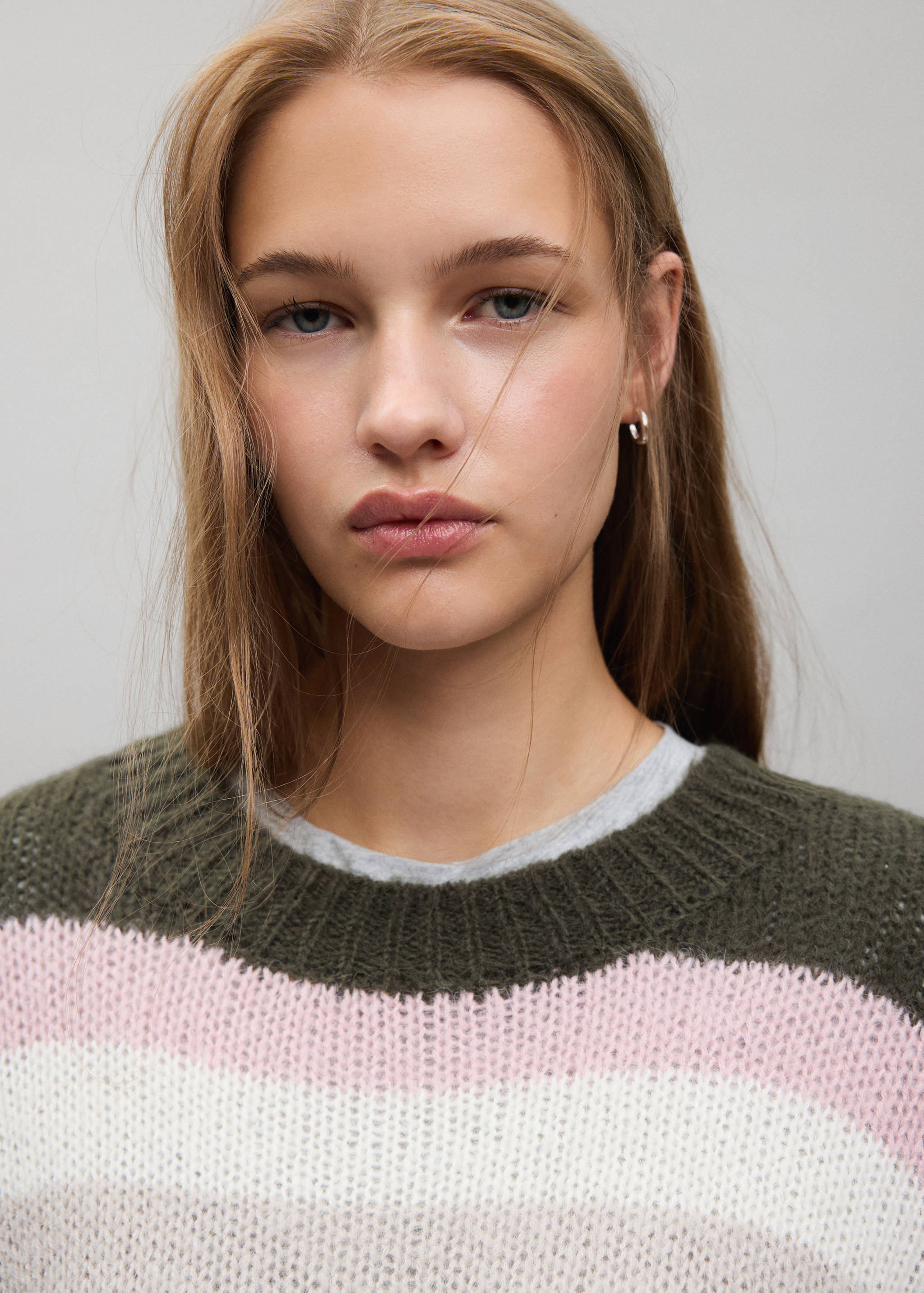 Close-up of a striped knitted jumper with a ribbed crew neck.