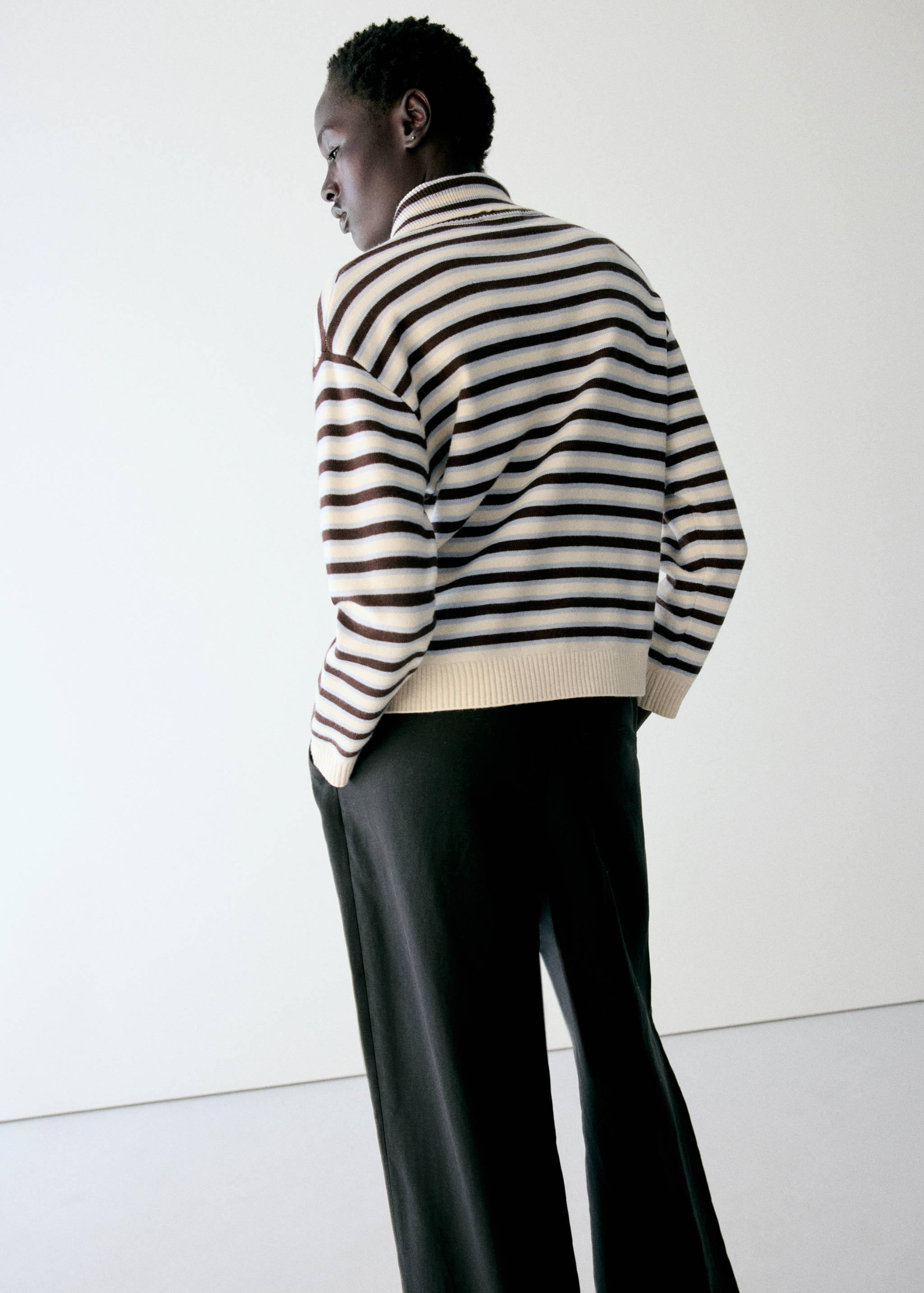 Striped turtleneck sweater in dark brown, cream and light blue, back view.