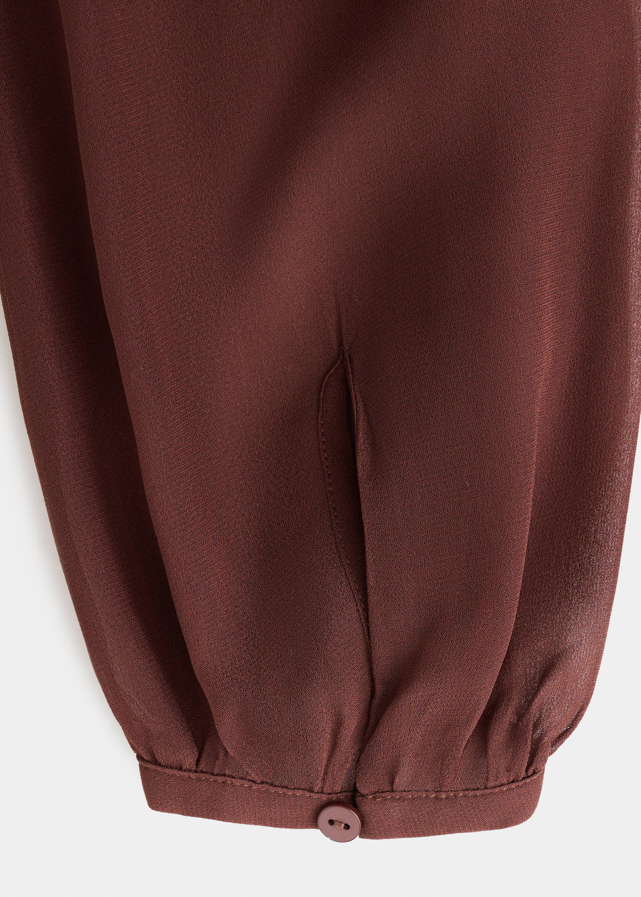 Burgundy dress fabric and buttoned sleeve detail.