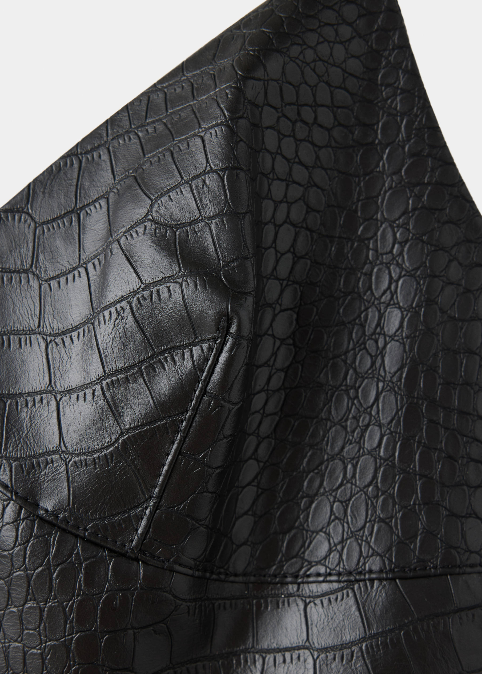 Close-up of a black crocodile-effect dress bust detail.