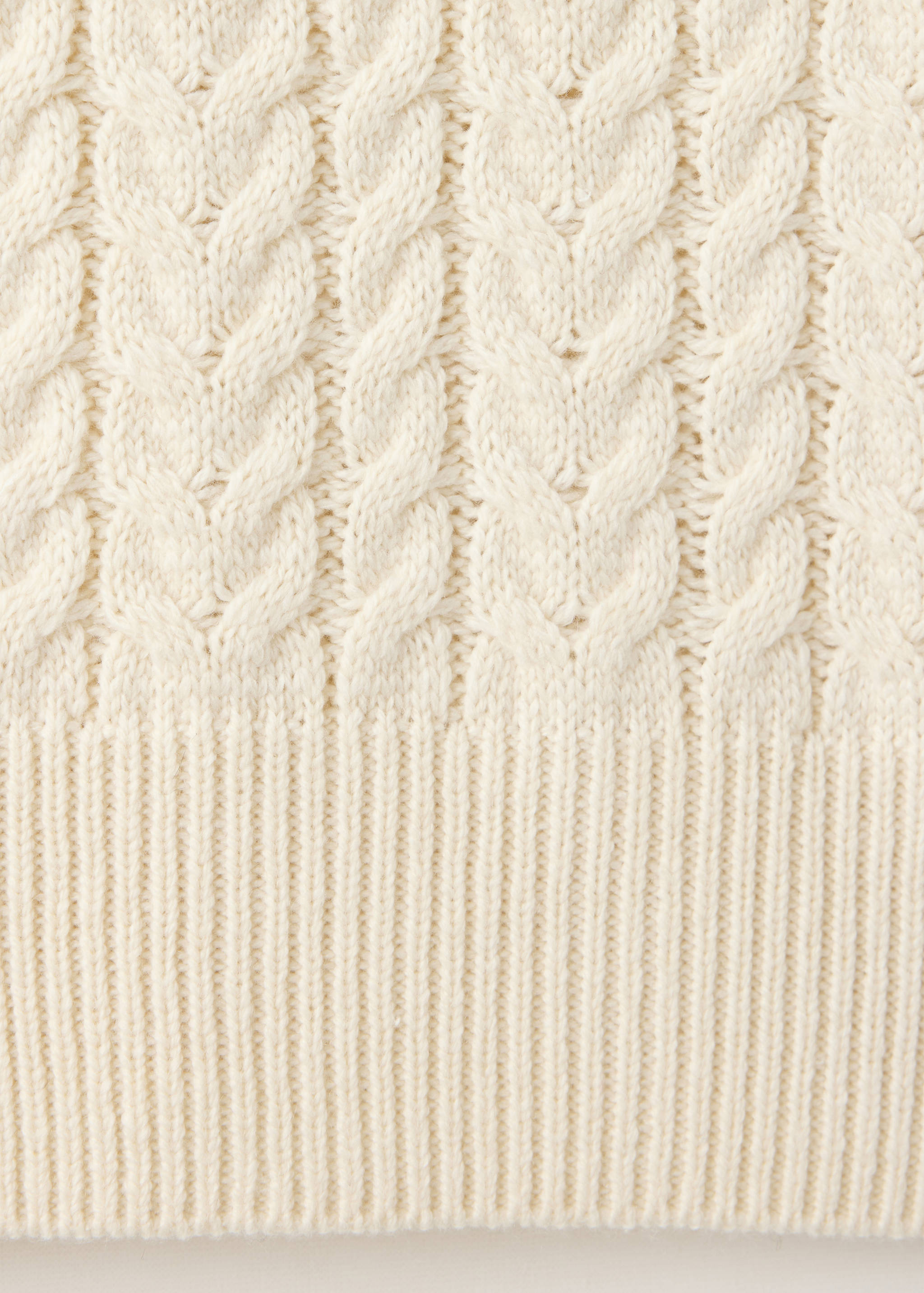 Off-white cable-knit jersey fabric detail showing the textured pattern.