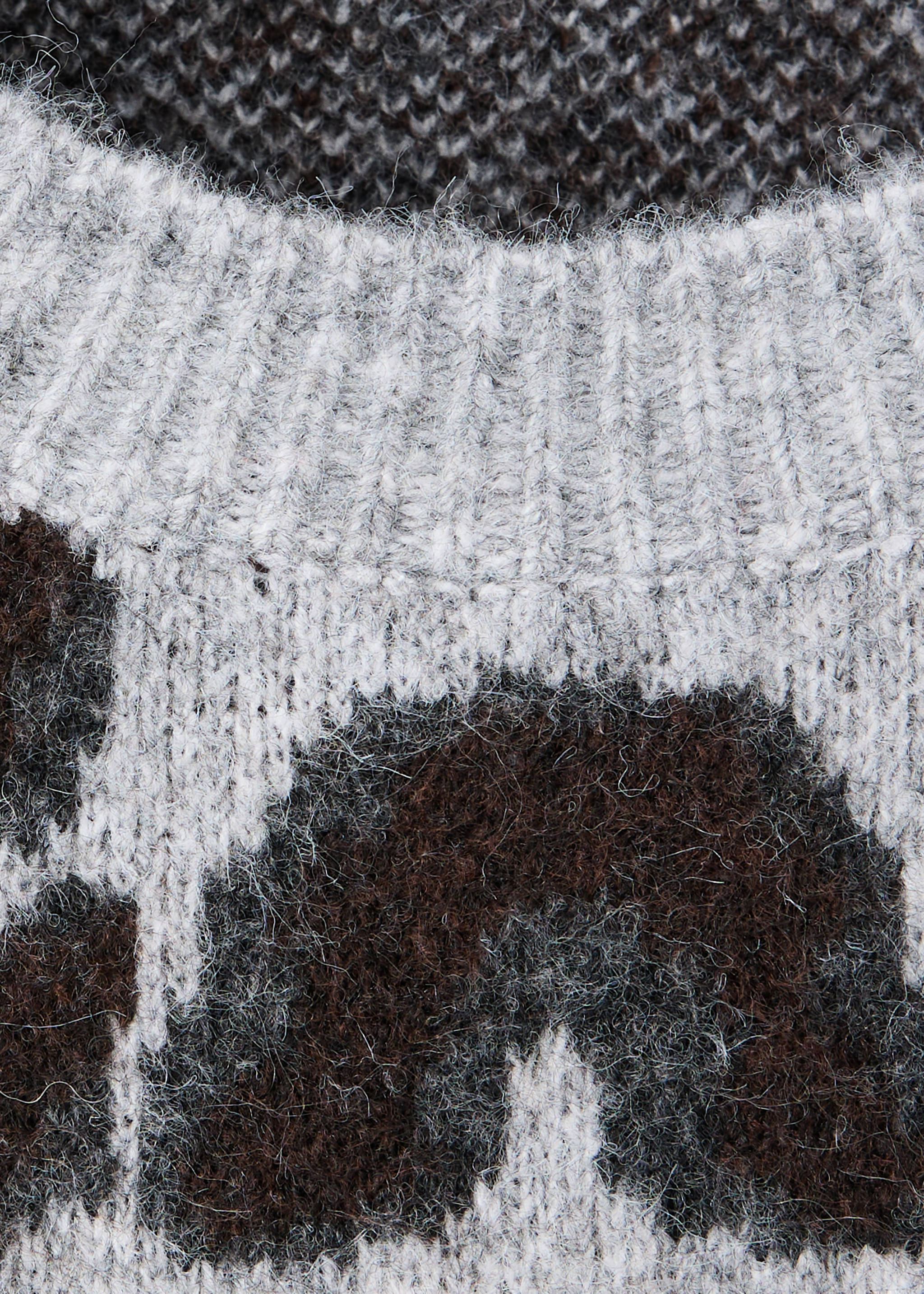 Close-up of a fuzzy knit sweater with a ribbed crew neckline and a brown and grey pattern.