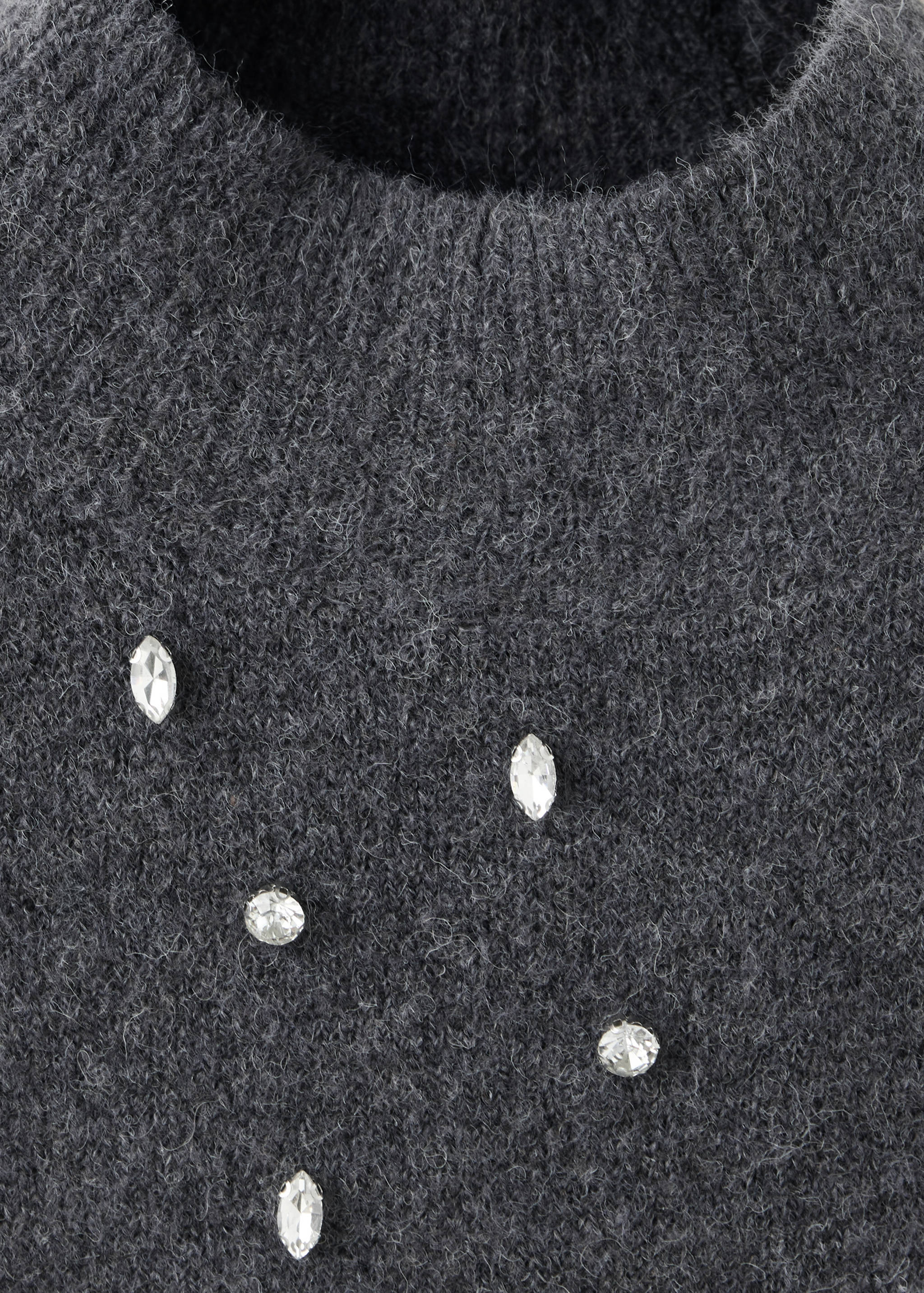 Close-up of a dark grey knit jersey with crystal rhinestone embellishments.