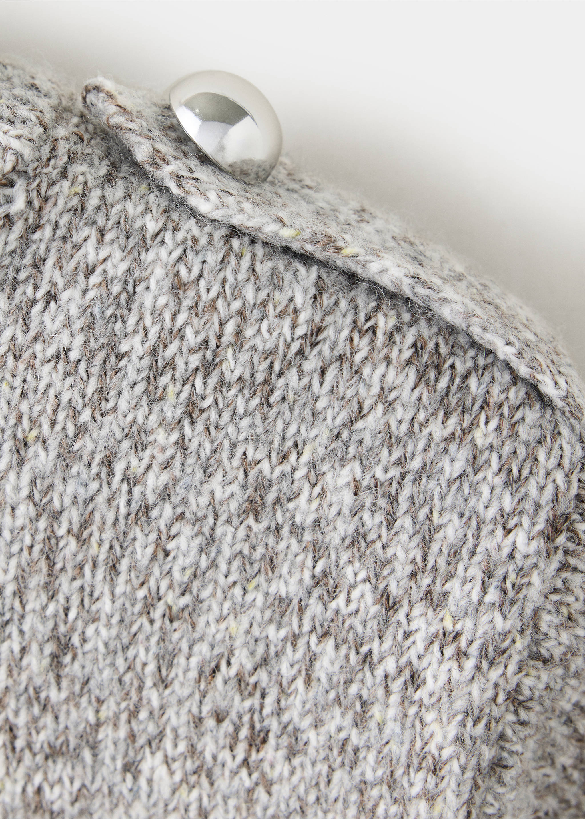 Close-up of a grey speckled knit jersey with a buttoned shoulder tab., Light Heather Grey. Ref: 37007809-00.
