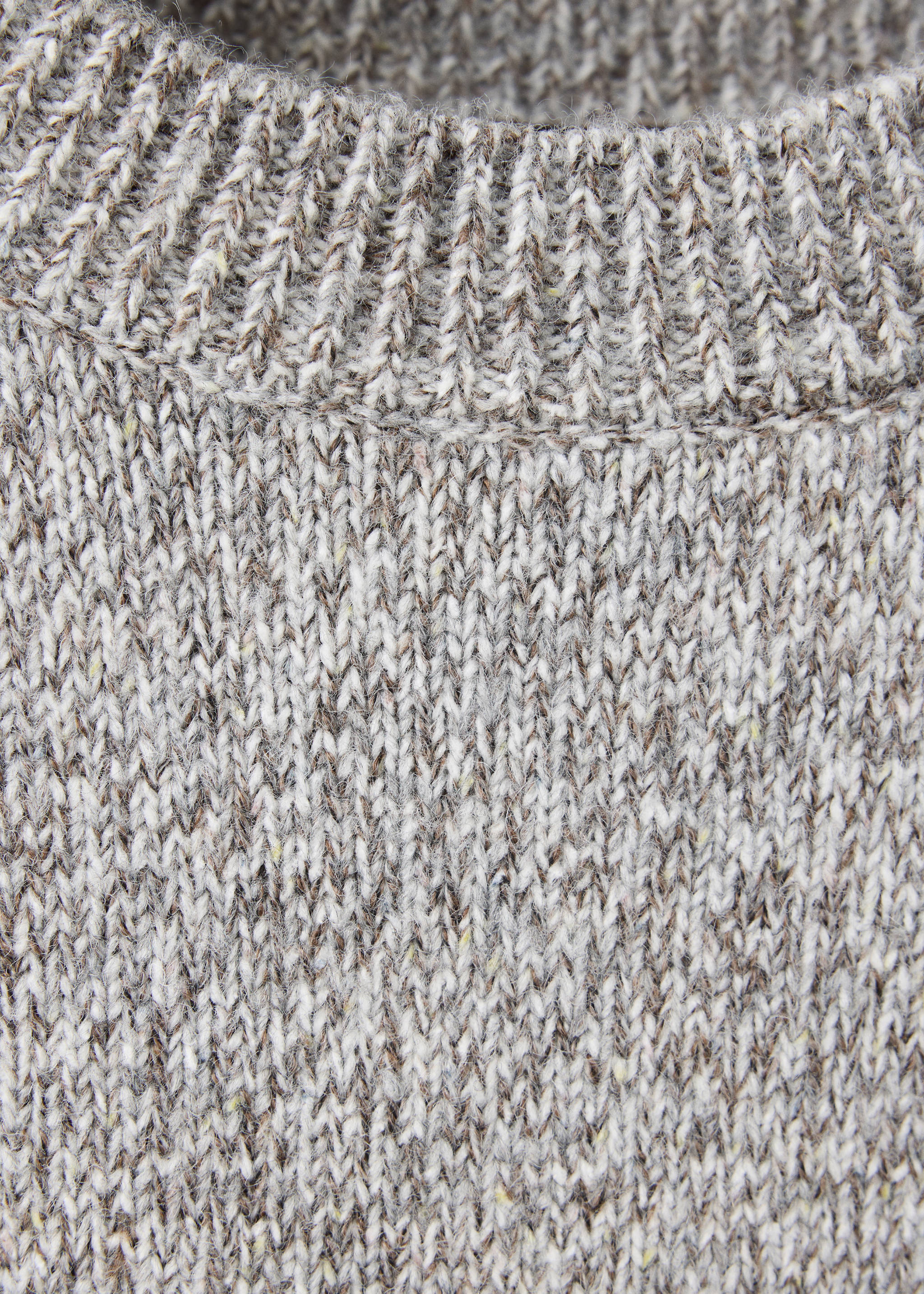 Close-up of a grey melange knit jersey featuring a ribbed crew neck.