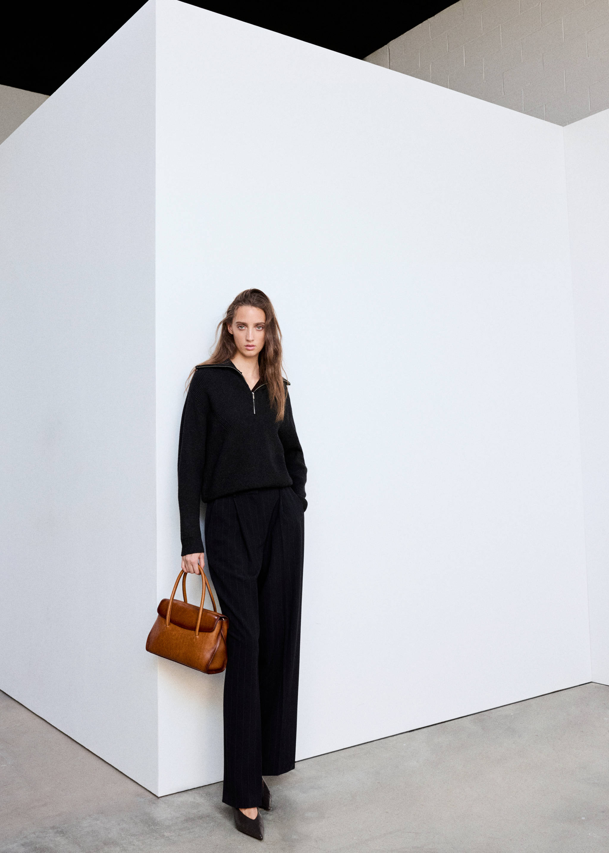 Black zip-collar jersey with a relaxed fit worn with matching trousers.